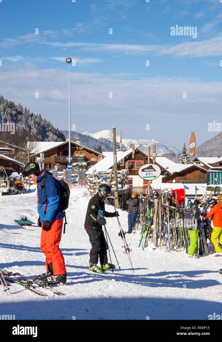 Gli sciatori rilassante al di fuori Le Pleney Bar, ristorante e giro in Gondola con montagne coperte di neve nelle Alpi francesi a Morzine Haute Savoie Francia Foto Stock