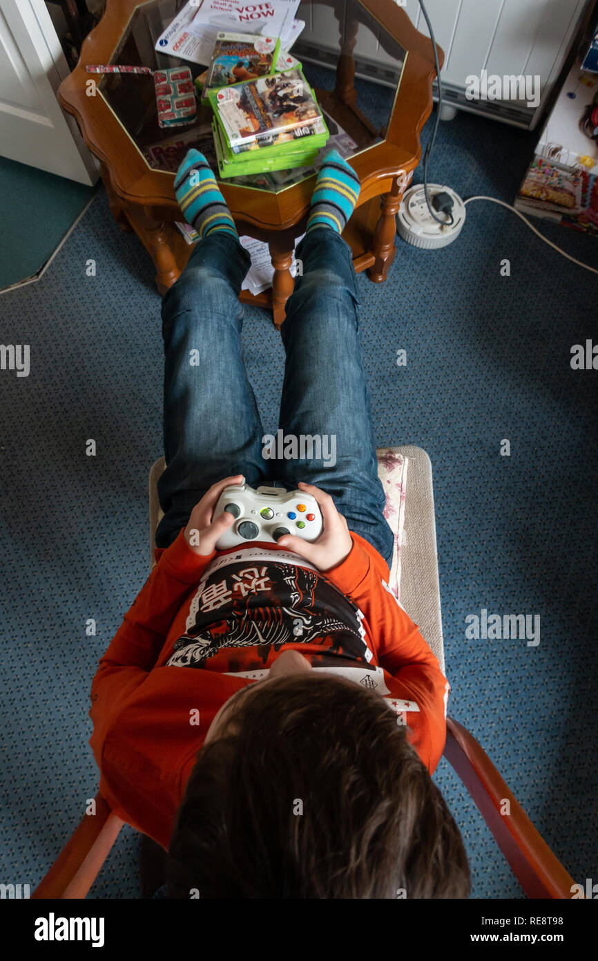 Guardando verso il basso in corrispondenza di un controller Xbox 360 in un ragazzo con le mani in mano. Foto Stock