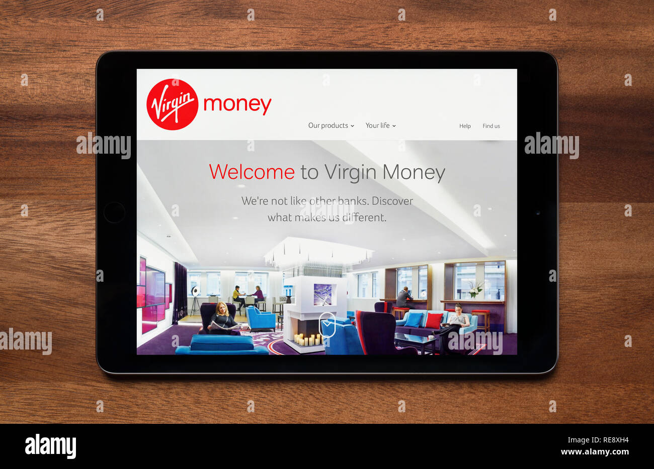 Il sito web della Vergine il denaro è visto su un tablet iPad, il quale è appoggiato su un tavolo di legno (solo uso editoriale). Foto Stock