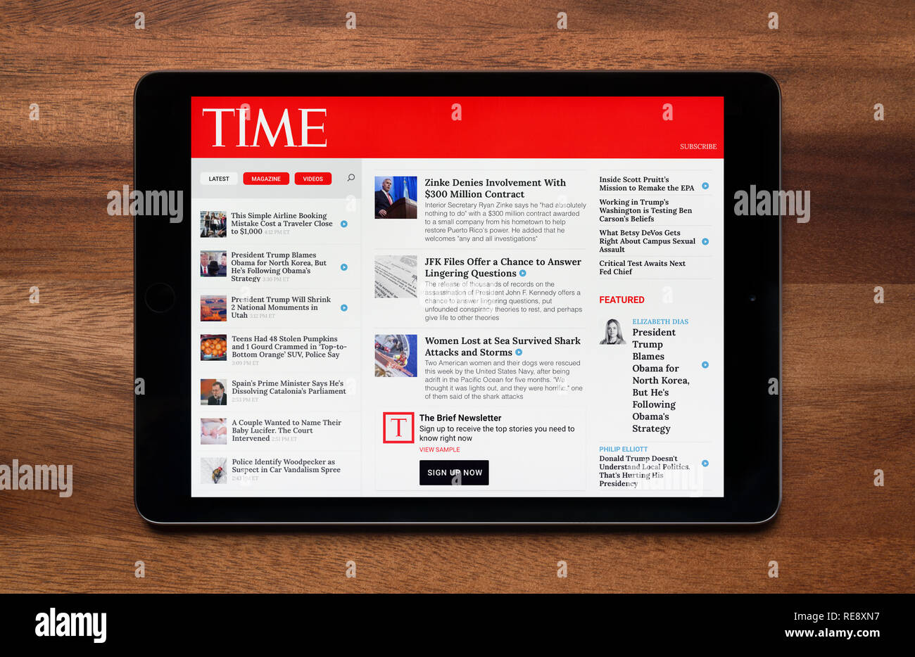 Il sito web della rivista Time è visto su un tablet iPad, il quale è appoggiato su un tavolo di legno (solo uso editoriale). Foto Stock