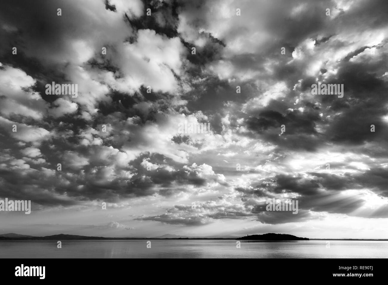 Splendido ampio angolo di visione di un lago con un enorme cielo di nuvole, al di sopra di un'isola Foto Stock