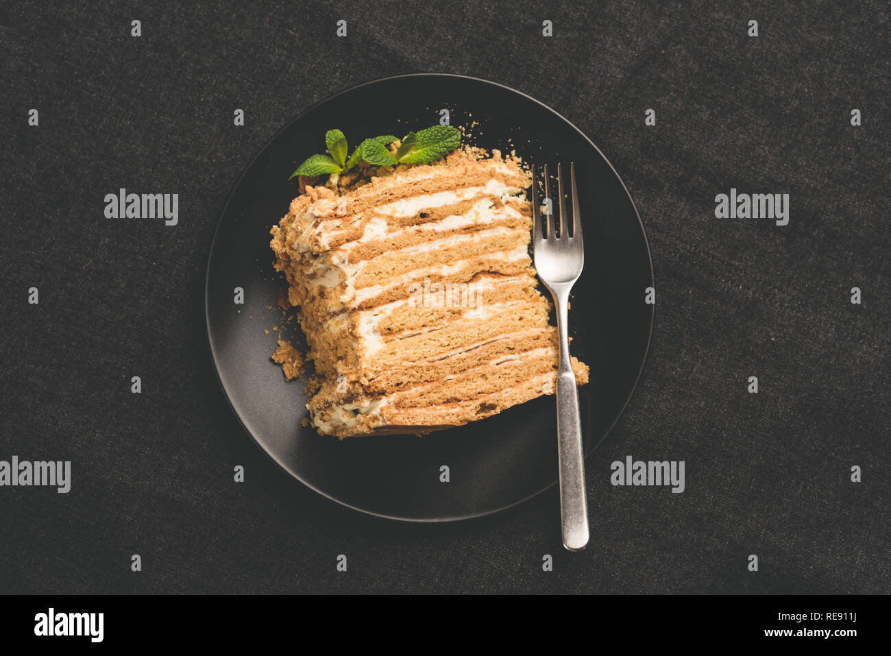 Il russo torta di miele Medovik sulla piastra nera, vista dall'alto, tonica immagine Foto Stock