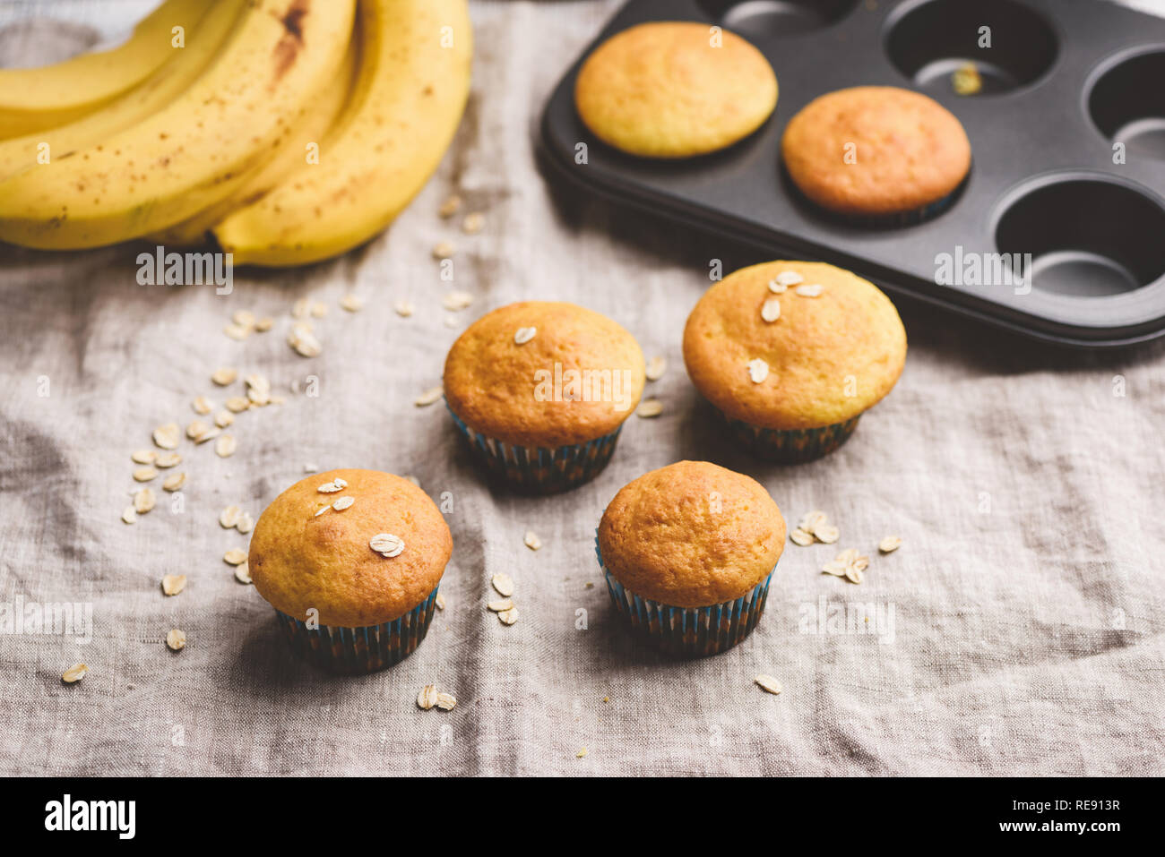 Vegano sano muffin alla banana con fiocchi di avena su lino sfondo. Immagine dai toni, il fuoco selettivo Foto Stock