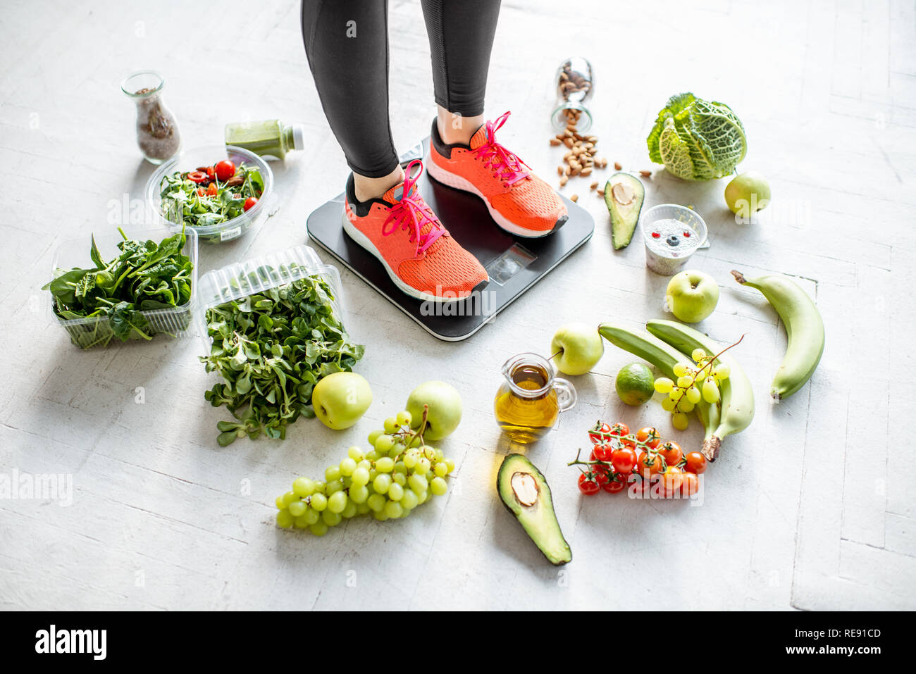 Sport donna di peso sulla bilancia con il cibo sano intorno a. La perdita di peso, cibo sano e sport concetto di stile di vita Foto Stock