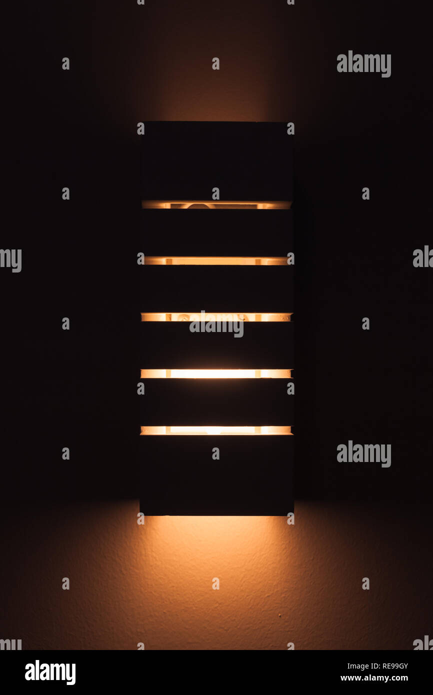 Moderna luce a parete con la linea vuoti incandescente nel buio, foto verticale Foto Stock
