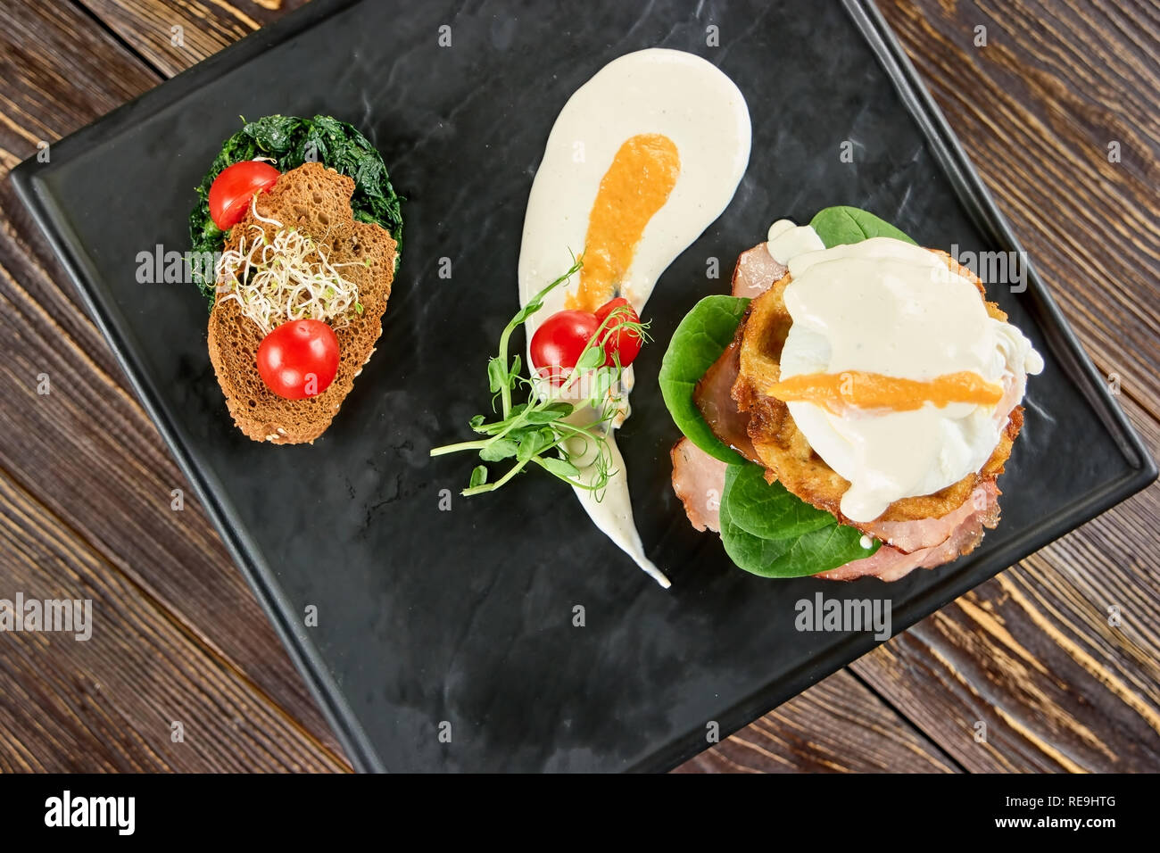 Uova, pane e verdure in diversi pasti. Strano che cercano il cibo sulla piastra rettangolare. Foto Stock