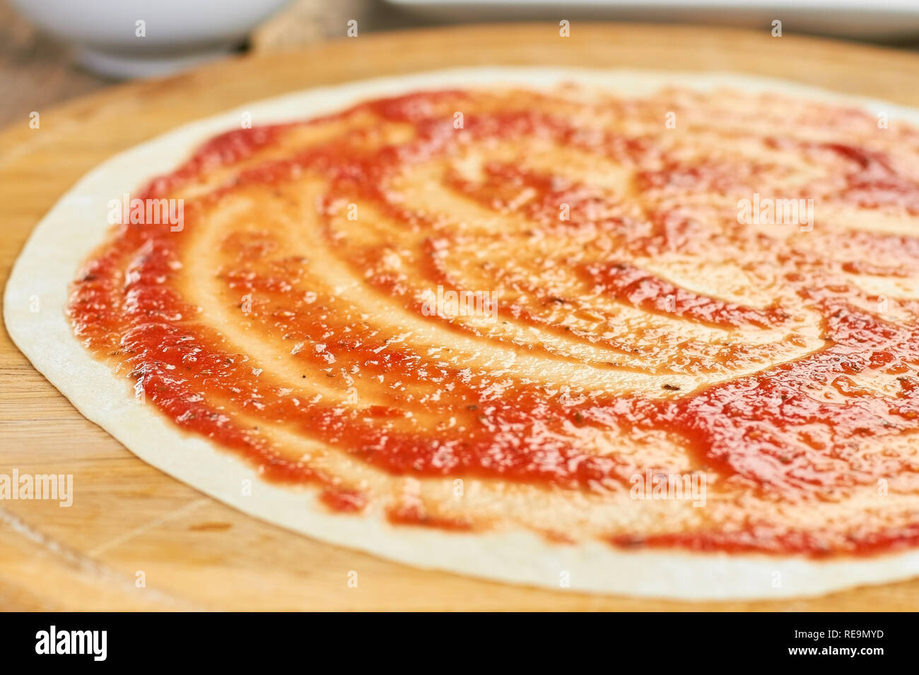 Sfondo vicino la base per pizza. Pasta con macchie di colore rosso ketchup. Foto Stock