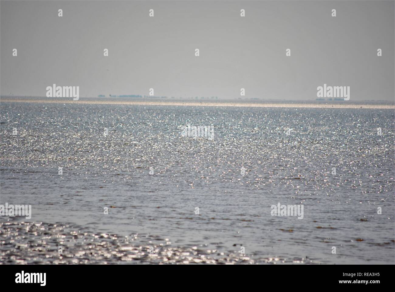 Sun scintillante sul mare con costa in th distanza del litorale in Inghilterra Foto Stock