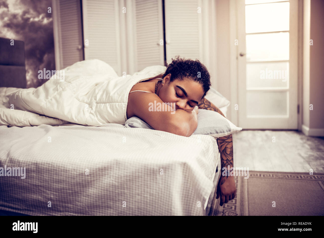 Dark-donna dai capelli con spesse sopracciglia dormire in bianco bad Foto Stock