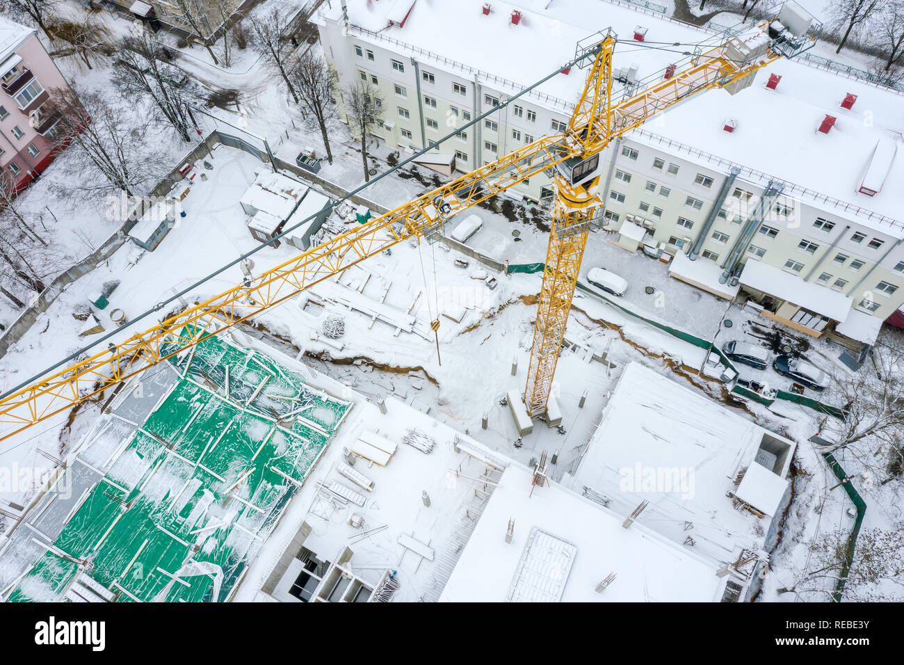 Antenna vista superiore della torre della gru al lavoro in un cantiere in inverno. drone fotografia Foto Stock
