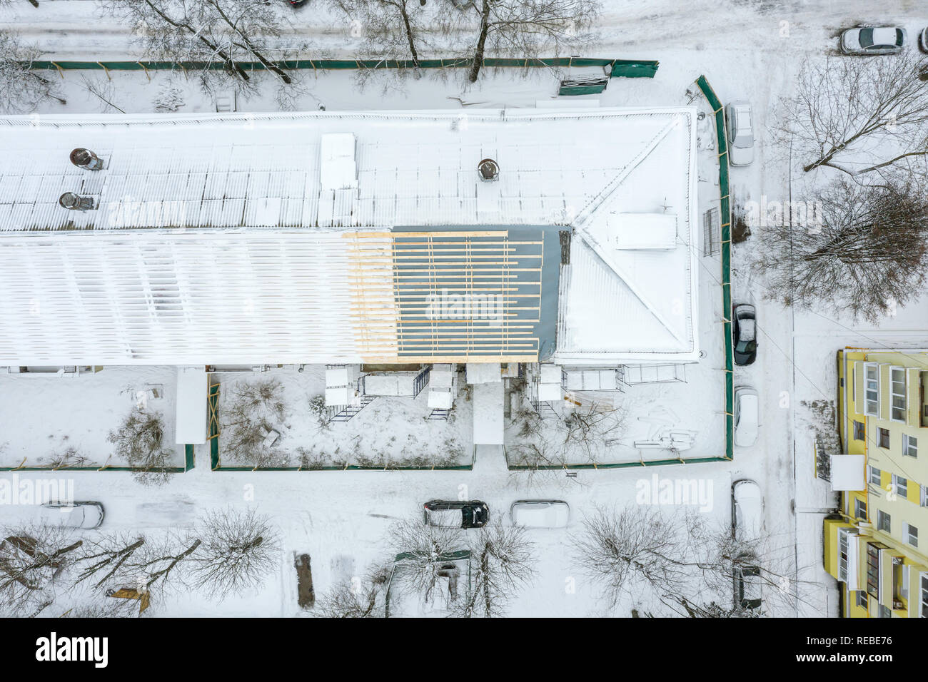 Antenna vista superiore della costruzione tetto sotto lavori di rinnovo in inverno. zona residenziale. drone fotografia Foto Stock