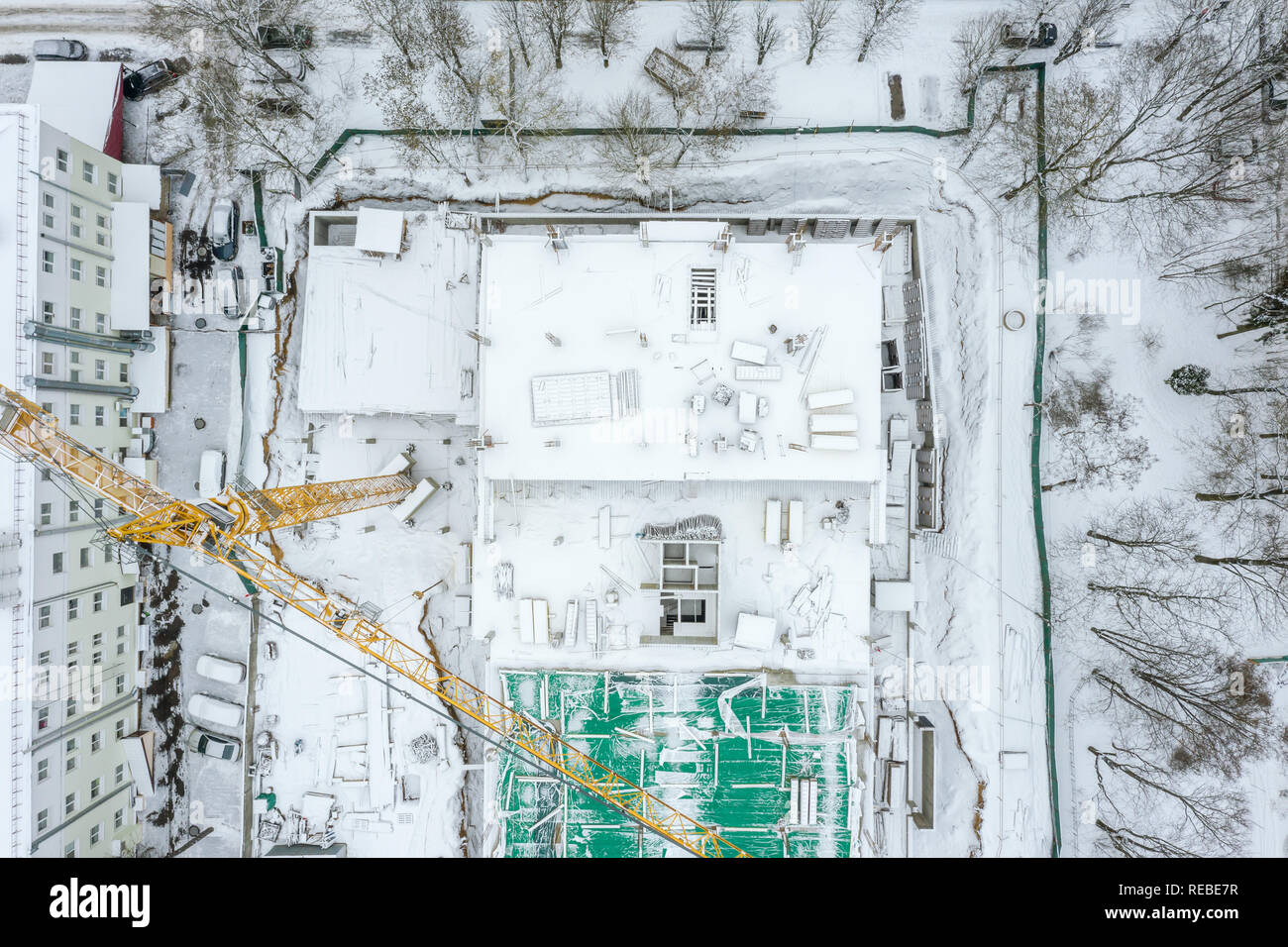 Birds Eye view di città di edilizia residenziale sito in inverno con alta gru a torre Foto Stock