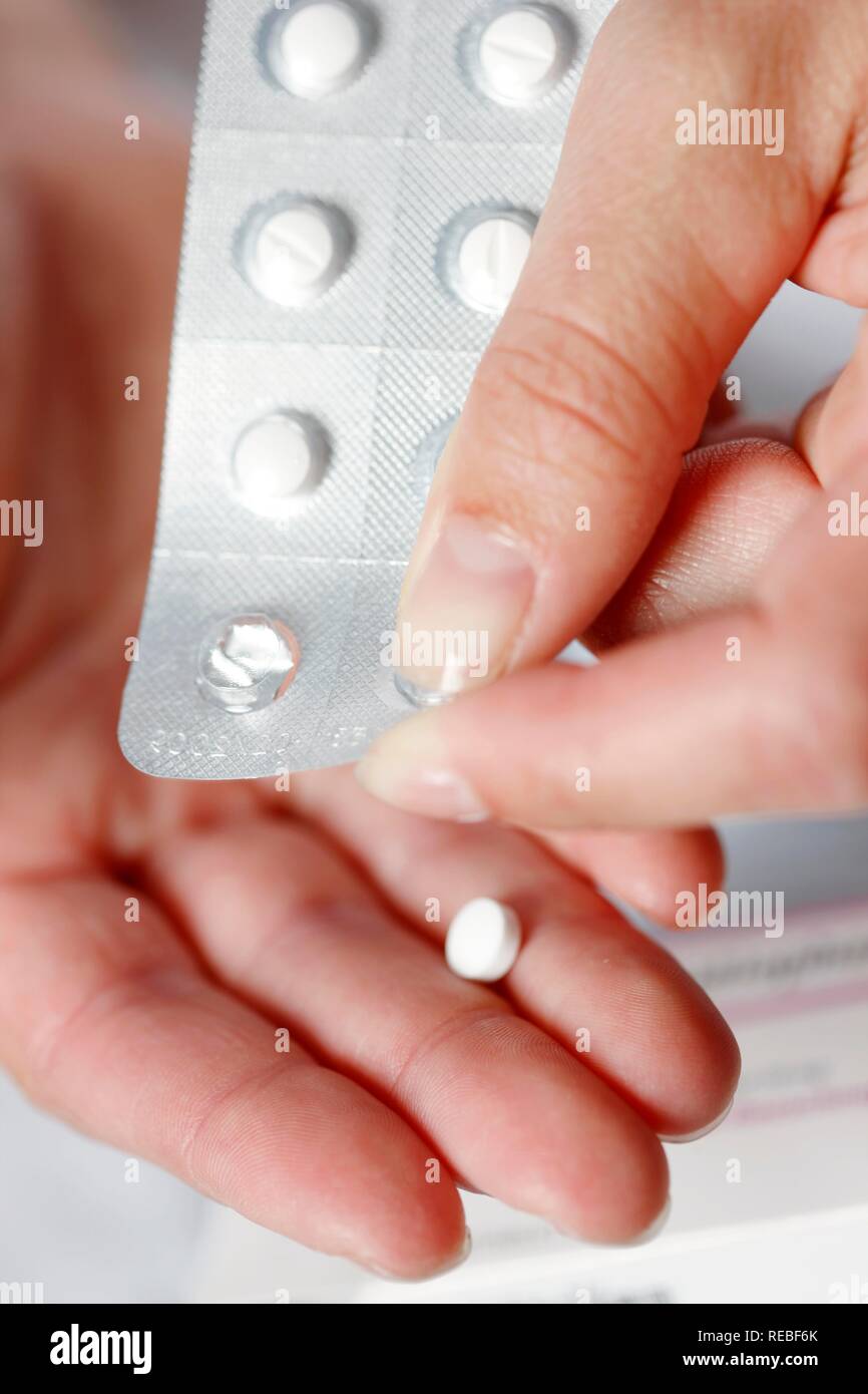 Compressa essendo spinto fuori di una confezione in blister Foto Stock