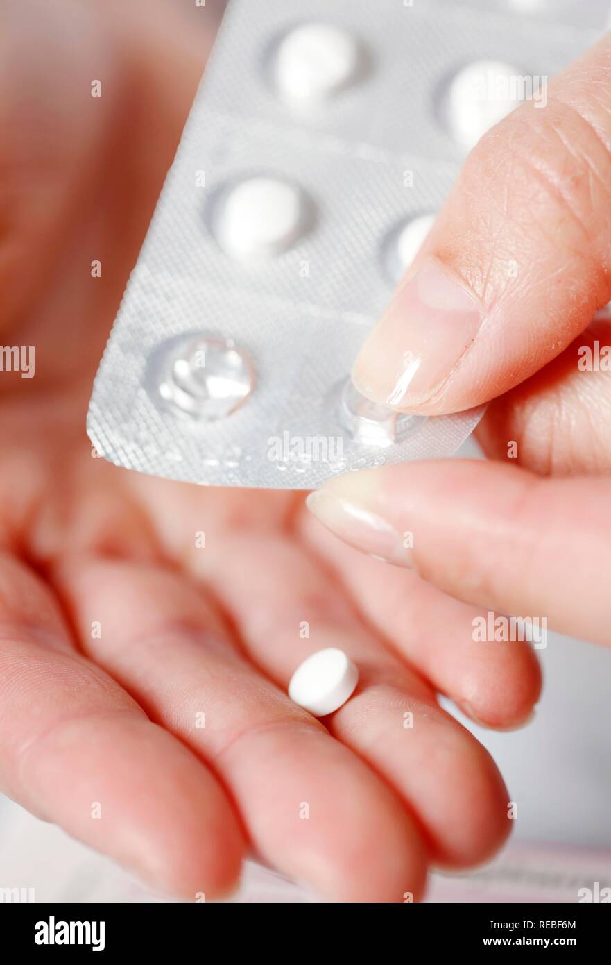 Compressa essendo spinto fuori di una confezione in blister Foto Stock