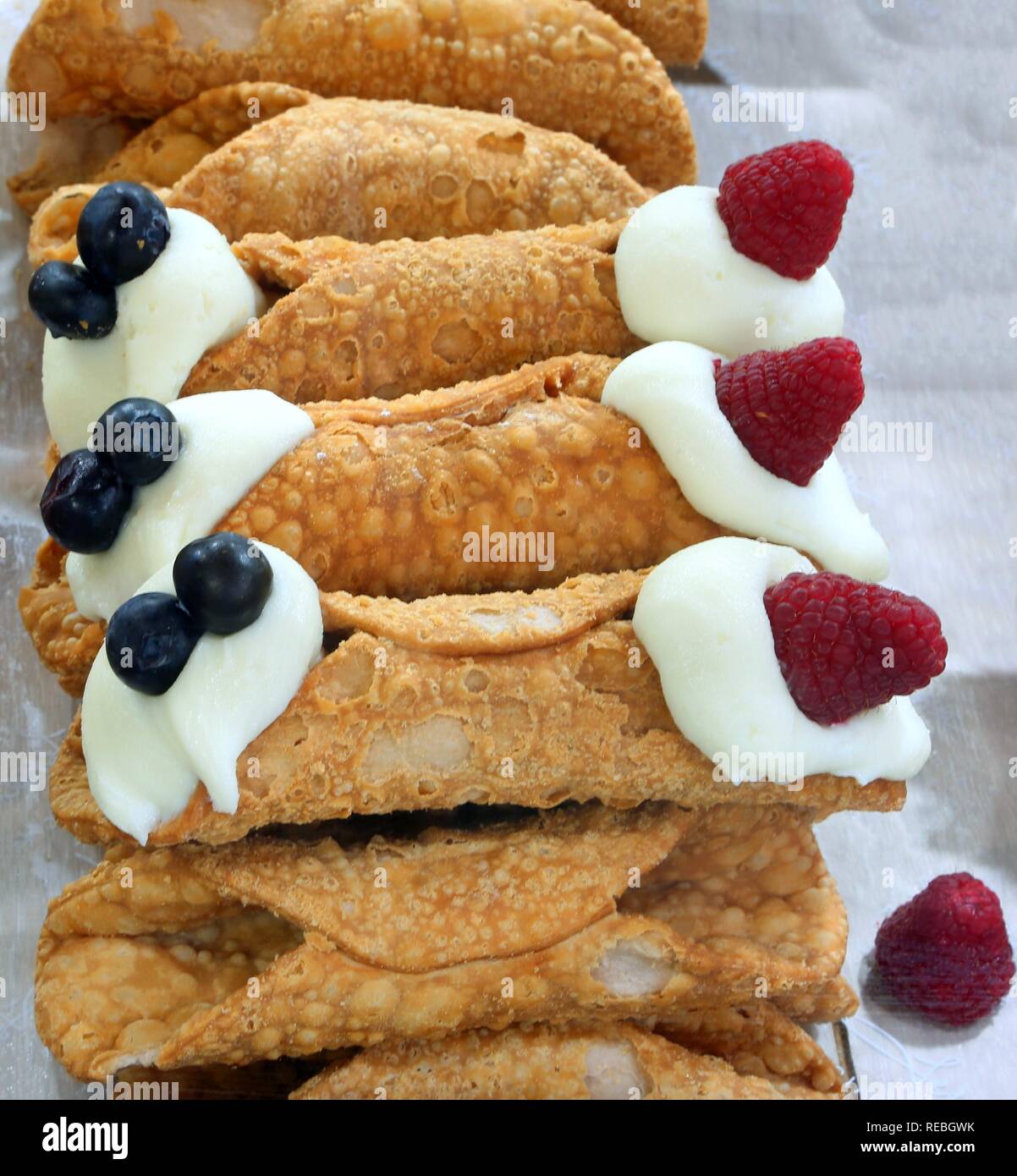 Tipica pasticceria siciliana cannolo chiamato farcito con crema e frutti di bosco Foto Stock