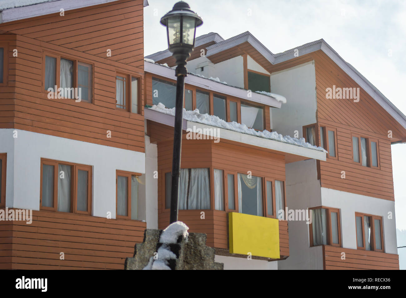 La neve sui tetti delle case alberghi in Kashmir Gulmarg con una street palo della luce nella parte anteriore Foto Stock