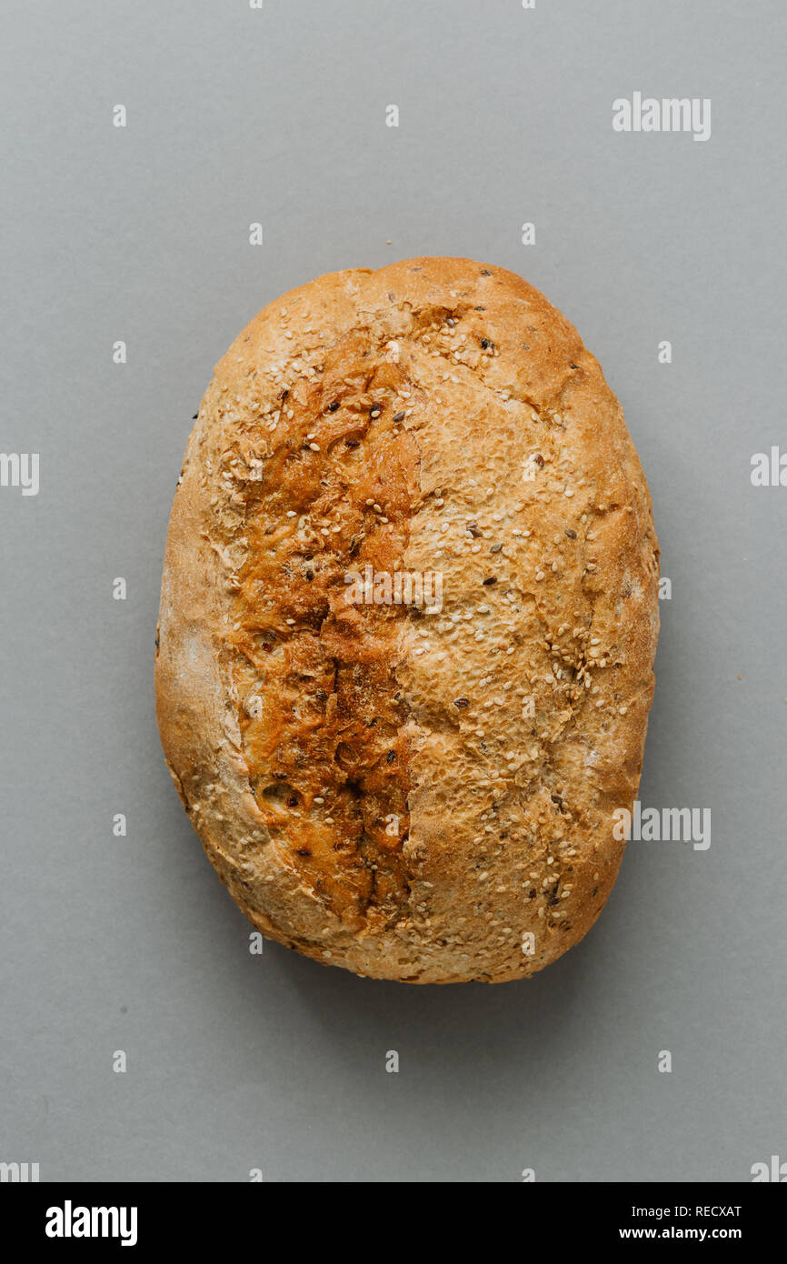 Intera pagnotta di pane croccante con su sfondo grigio vista superiore Foto Stock