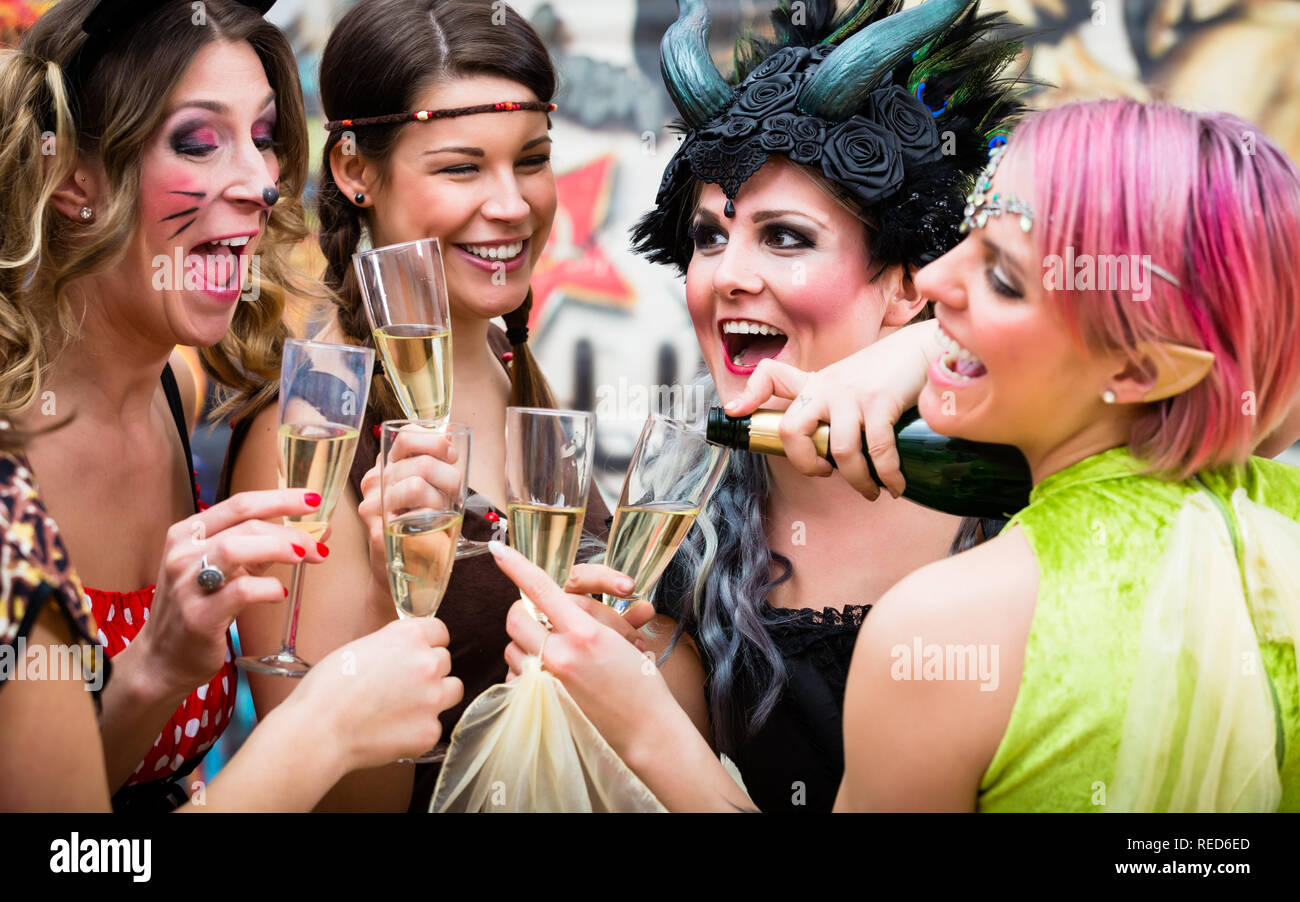 Ragazze alla sfilata di carnevale bicchieri tintinnanti con champagne Foto Stock