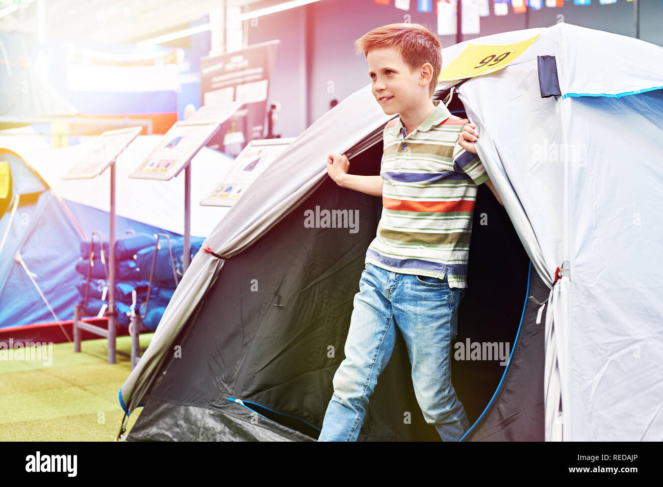 Ragazzo in una tenda turistica in un negozio di articoli sportivi Foto Stock