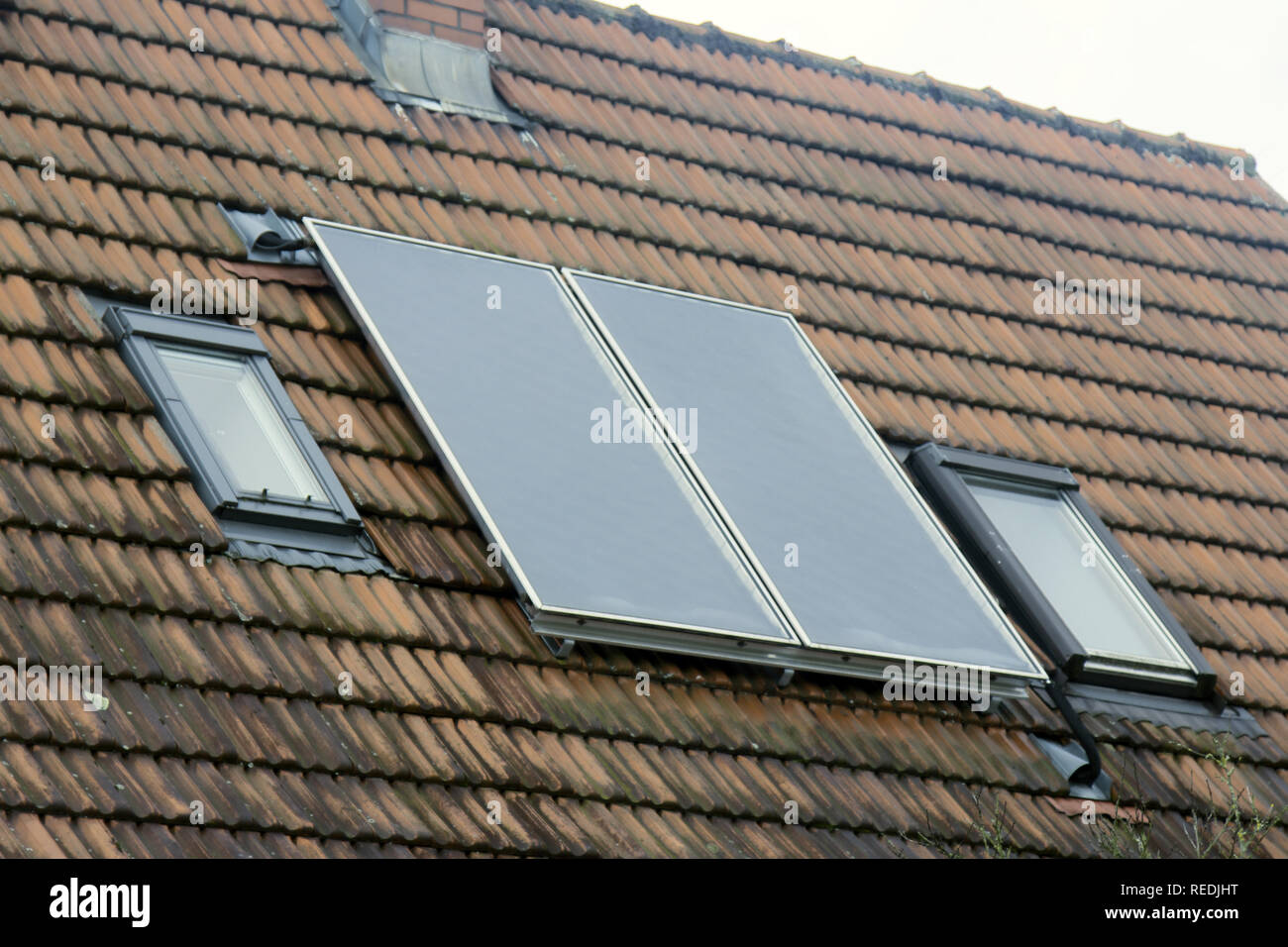 Batteria solare sul tetto di tegole della casa della città (tetto-integrated solar array) tra due finestre dormer. Baden-Baden Foto Stock