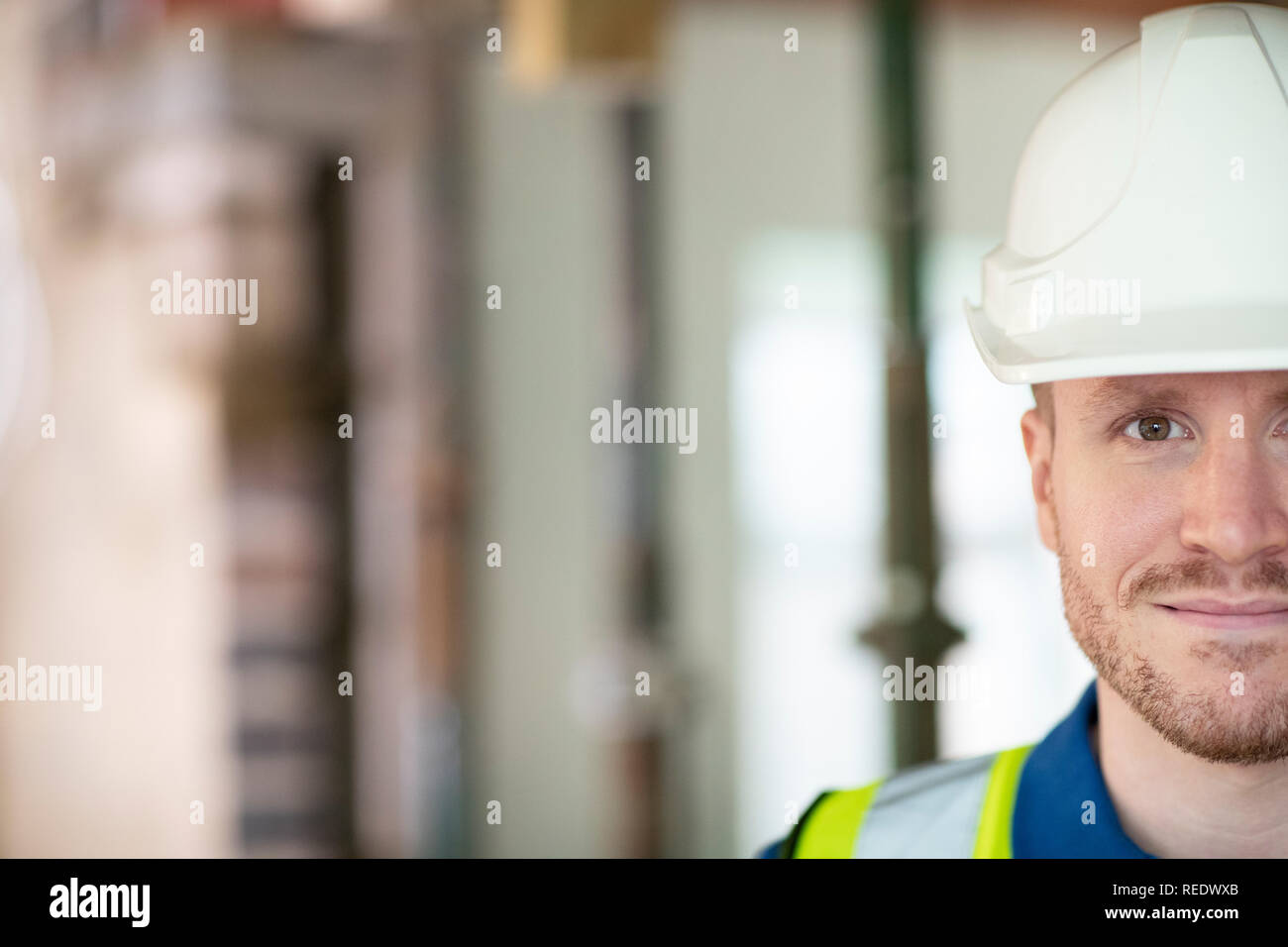 Ritagliato ritratto maschile di lavoratore edile sul sito di costruzione INDOSSARE ELMETTO Foto Stock