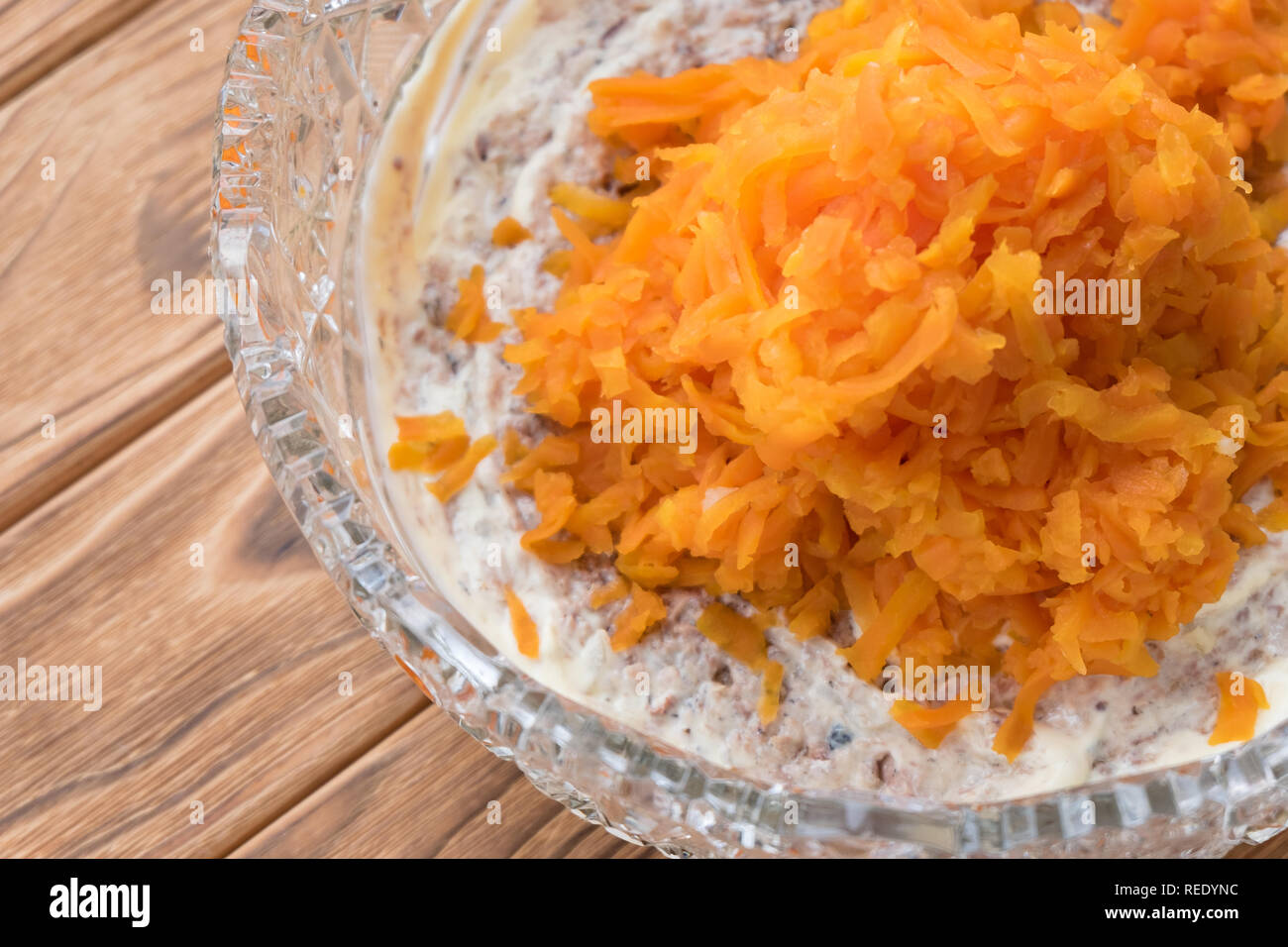Il processo di cottura insalata di pesce Mimosa. La posa di carote e maionese Foto Stock