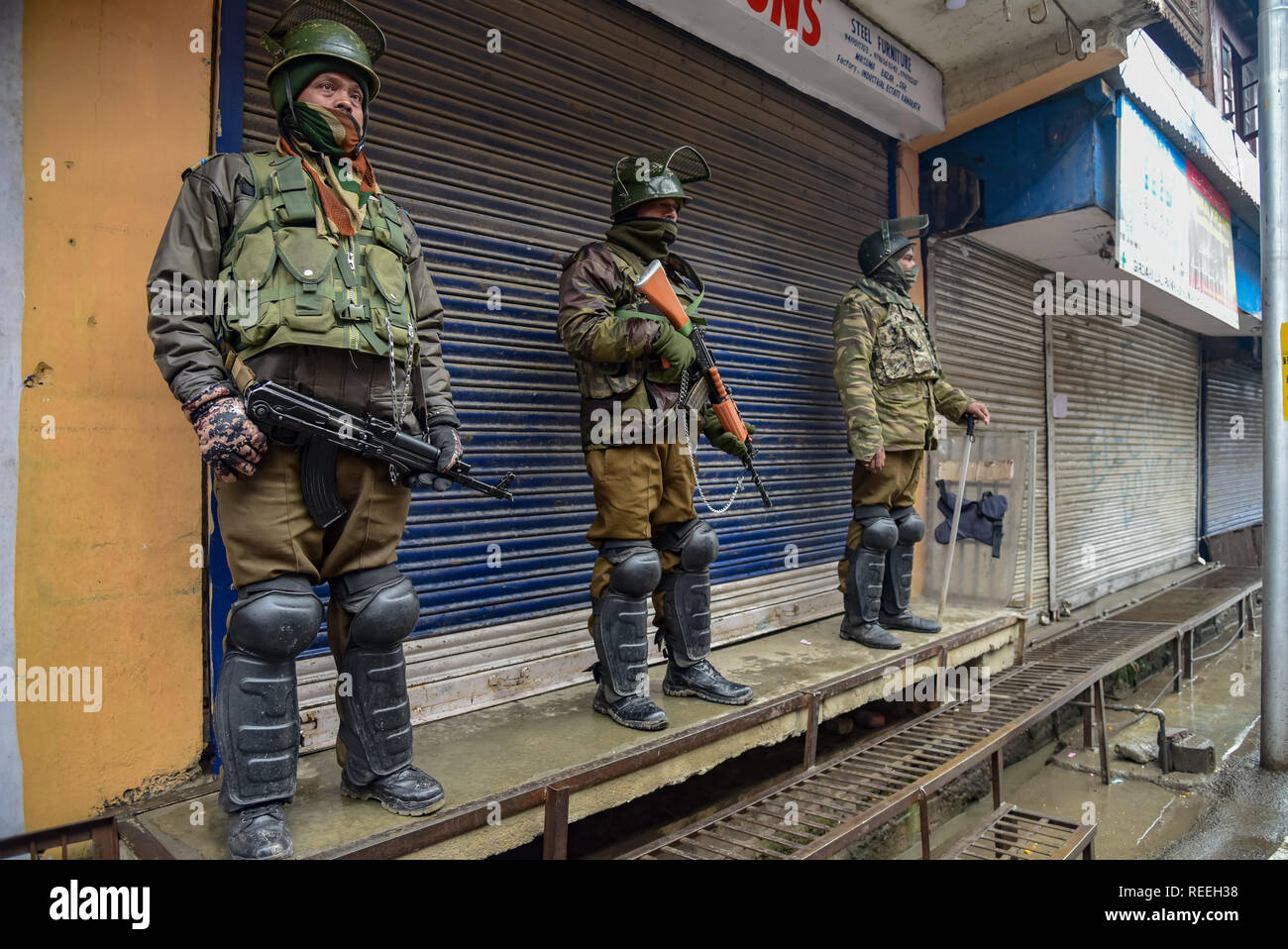 Esercito indiano uomini visto avviso in piedi nella parte anteriore del negozio chiuso durante le restrizioni in Srinagar. Kashmiris mark xxix anniversario della Gaw Kadal massacro. Più di 50 del Kashmir civili sono stati uccisi e più di 250 popoli sono stati feriti quando l'esercito indiano aperto elenchi puntati sui manifestanti del Kashmir a Gaw Kadal bridge a Srinagar il 21 gennaio 1990. Le autorità impongono delle restrizioni nel Gaw Kadal area di Srinagar per impedire Anti Indian proteste contro le uccisioni. Foto Stock