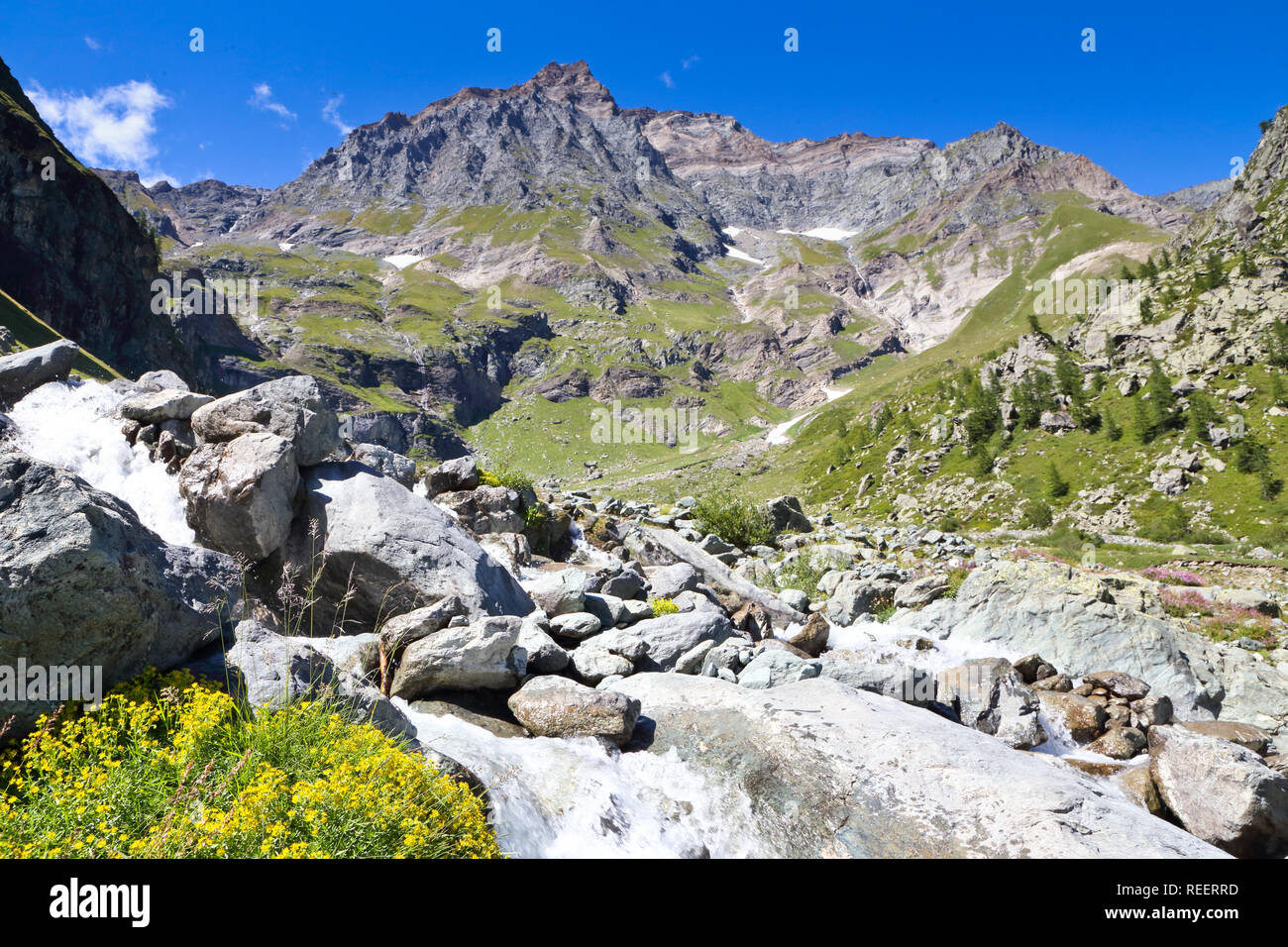 Immagine di un paesaggio di montagna con montagne, acqua, capanne Foto Stock