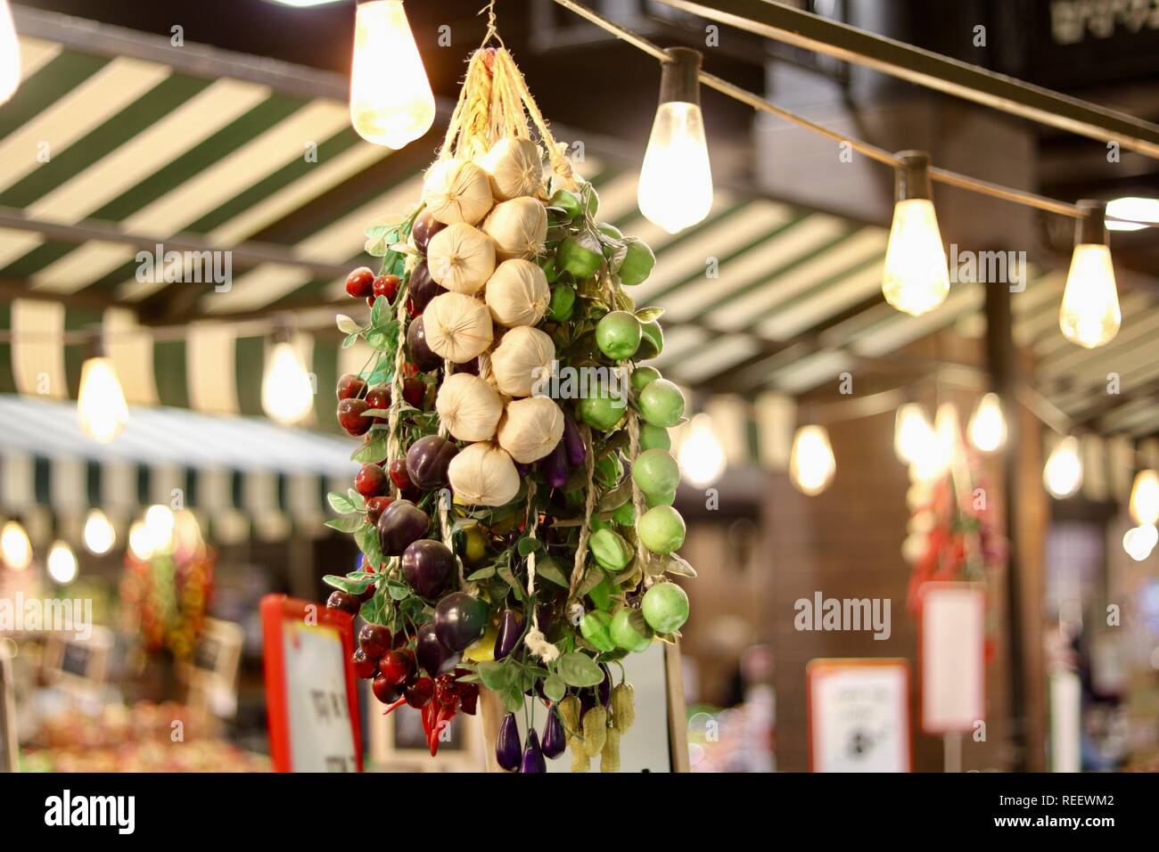 I chiodi di garofano di aglio sospeso su una fila di lampadine lungo il lato verde e uve a bacca rossa. Molto artistico. Foto Stock