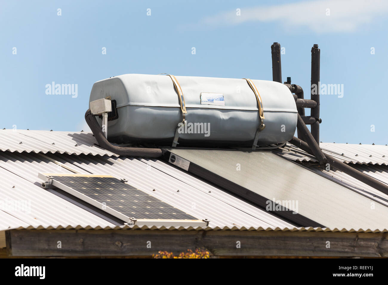 Geyser solare sul tetto metallico e di rispettosa dell'ambiente casa con del pannello solare sul tetto per vivere verde e l'efficienza energetica in Sud Africa Foto Stock