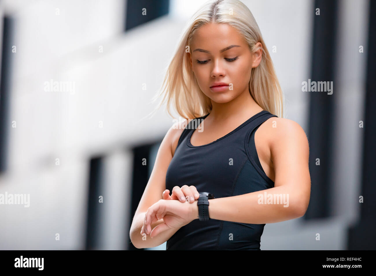 Donna controllando la frequenza cardiaca utilizzando Smart guarda dopo allenamento Foto Stock