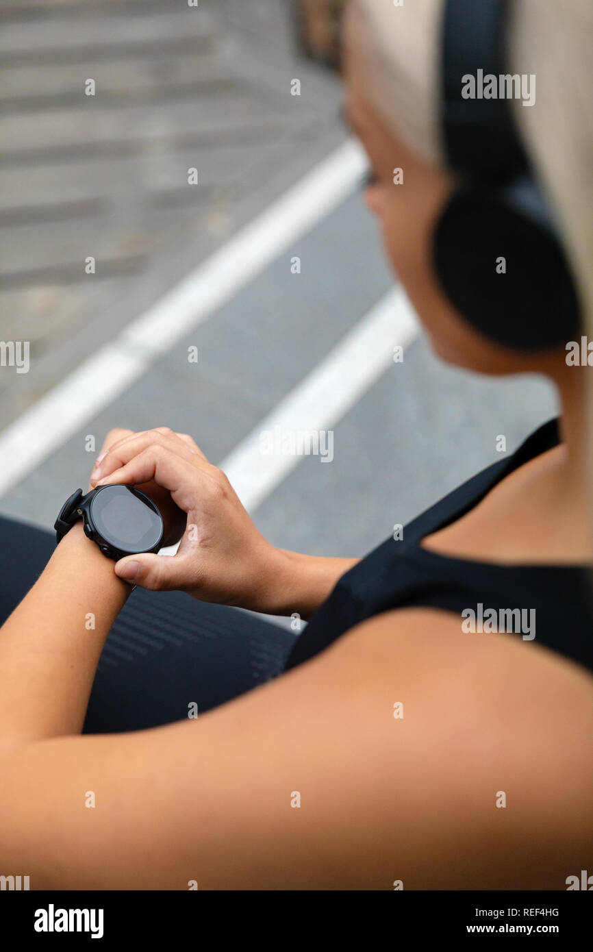 Montare donna impostazione il fitness smart watch per l'esecuzione. Foto Stock