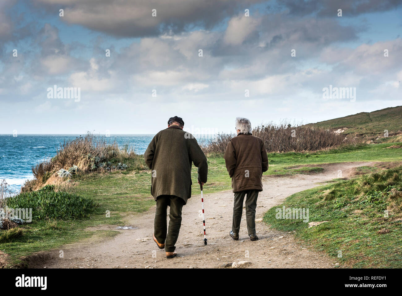 Una coppia matura camminando lungo la costa sud occidentale il percorso sul promontorio in Newquay Cornwall; Foto Stock