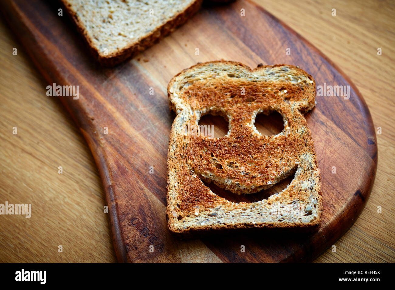 Fetta di pane tostato marrone sul tagliere Foto Stock