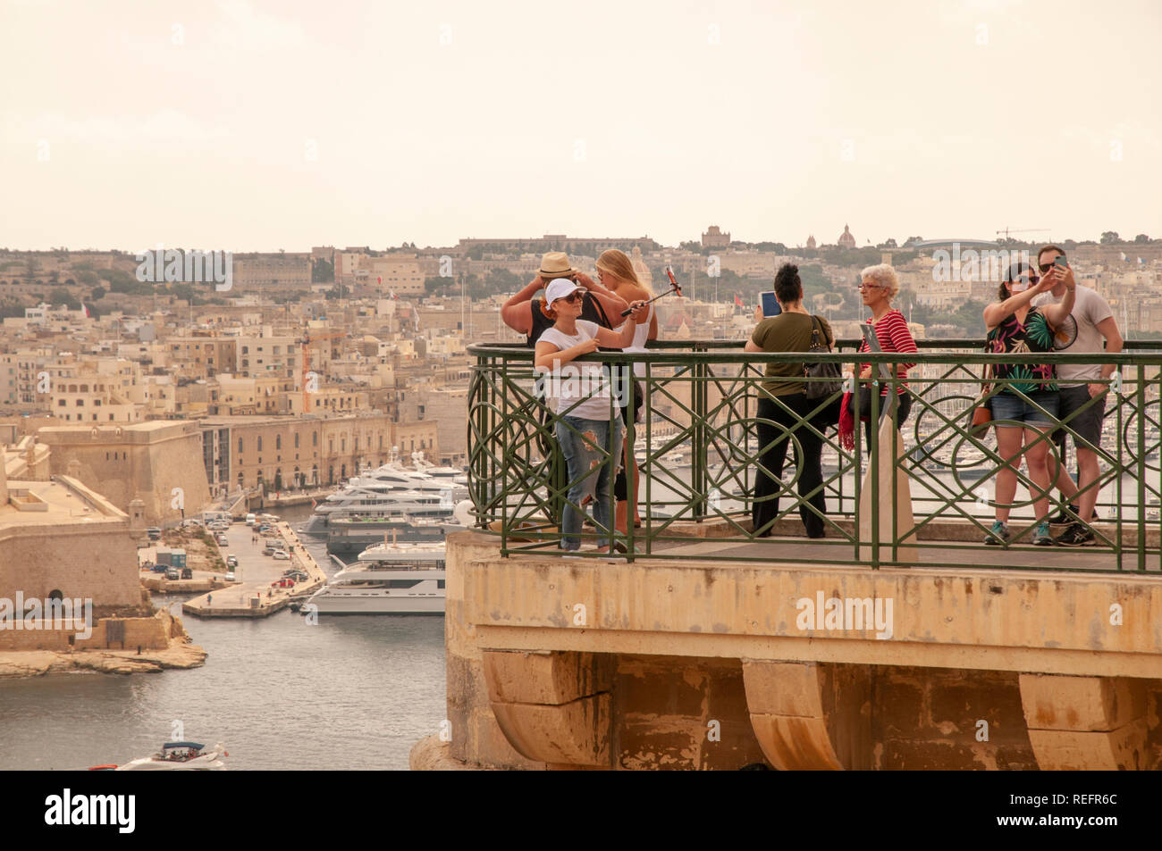 I visitatori al Upper Barrakka Gardens a La Valletta, Malta, ammirando il panorama e scattare foto sul Grand Harbour. Foto Stock