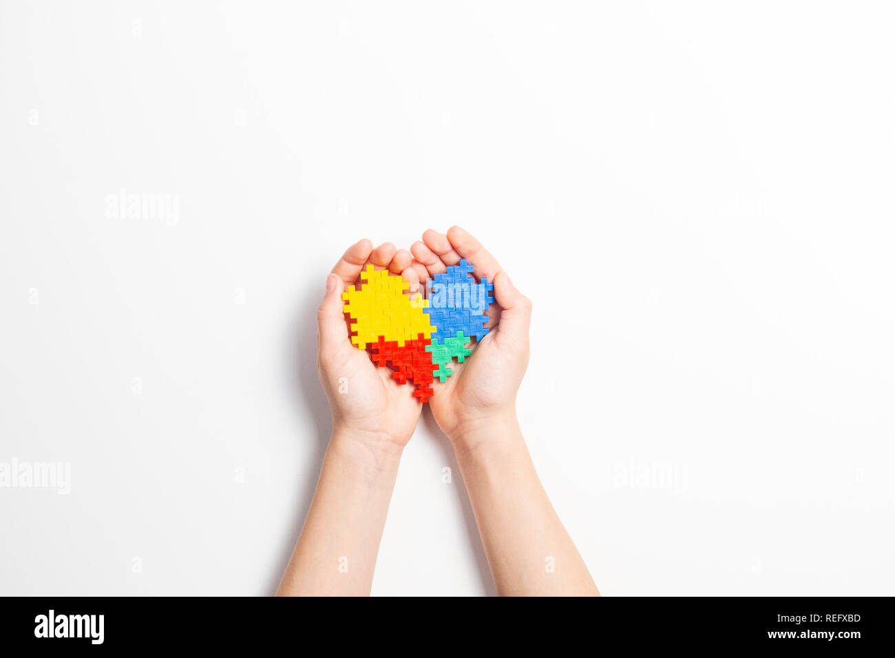 Bambino mani cuore colorato su sfondo bianco. Mondo autismo consapevolezza giorno di concetto Foto Stock