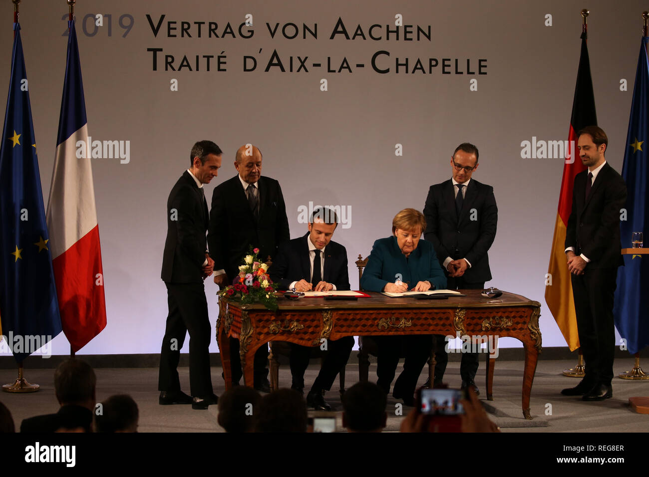 Aachen, Germania. Il 22 gennaio, 2019. Emmanuel Macron, Presidente della Francia e il Cancelliere tedesco Angela Merkel (CDU), firmano il trattato, osservata da Jean-Yves Le Drian (secondo da sinistra), il ministro degli Esteri francese, e Heiko Maas (seconda da destra, SPD), il Ministro degli esteri tedesco, durante la cerimonia della firma della nuova amicizia franco-tedesca trattato nell'incoronazione hall del municipio. Il cosiddetto Trattato di Aquisgrana segue dal Élysee trattato di amicizia firmato da Adenauer e de Gaulle nel 1963. Credito: Oliver Berg/dpa/Alamy Live News Foto Stock