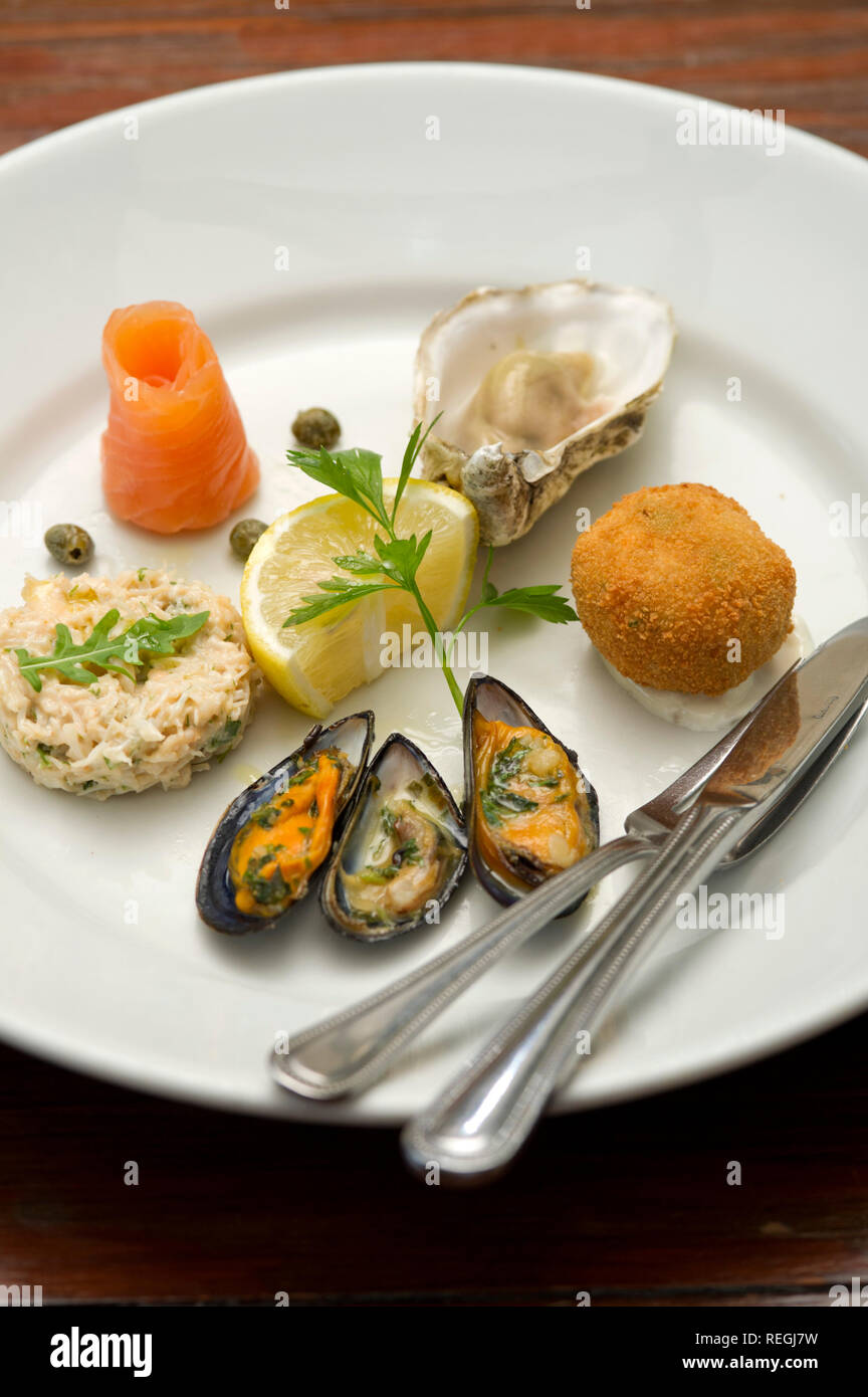 Un motorino di avviamento di salmone affumicato, ostrica, granchio crocchetta, cozze e sgombro patè. Foto Stock