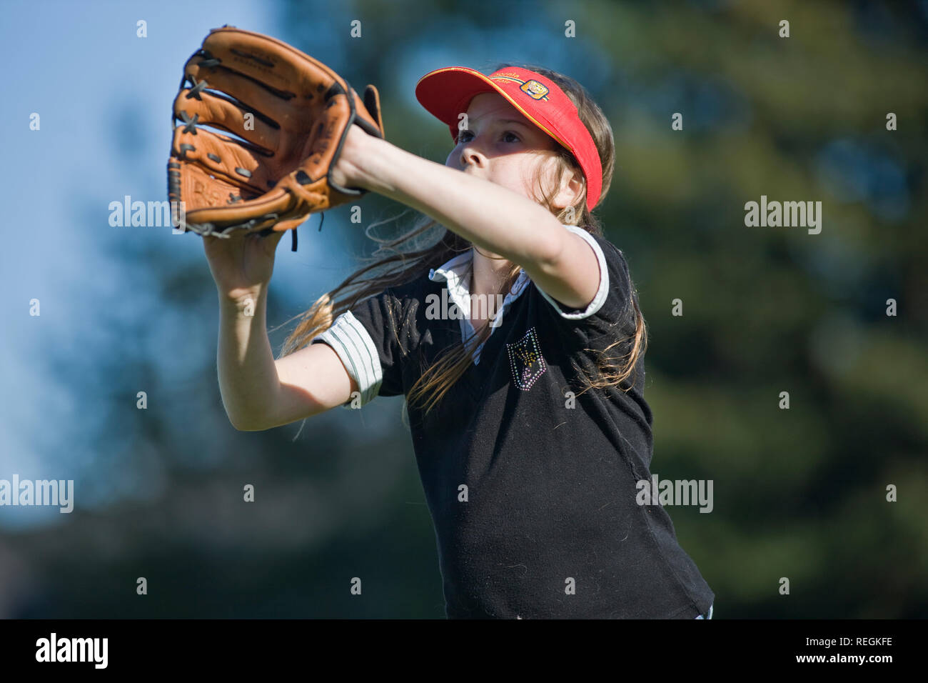 Ragazza con un guanto da baseball in preparazione per la cattura di una sfera. Foto Stock