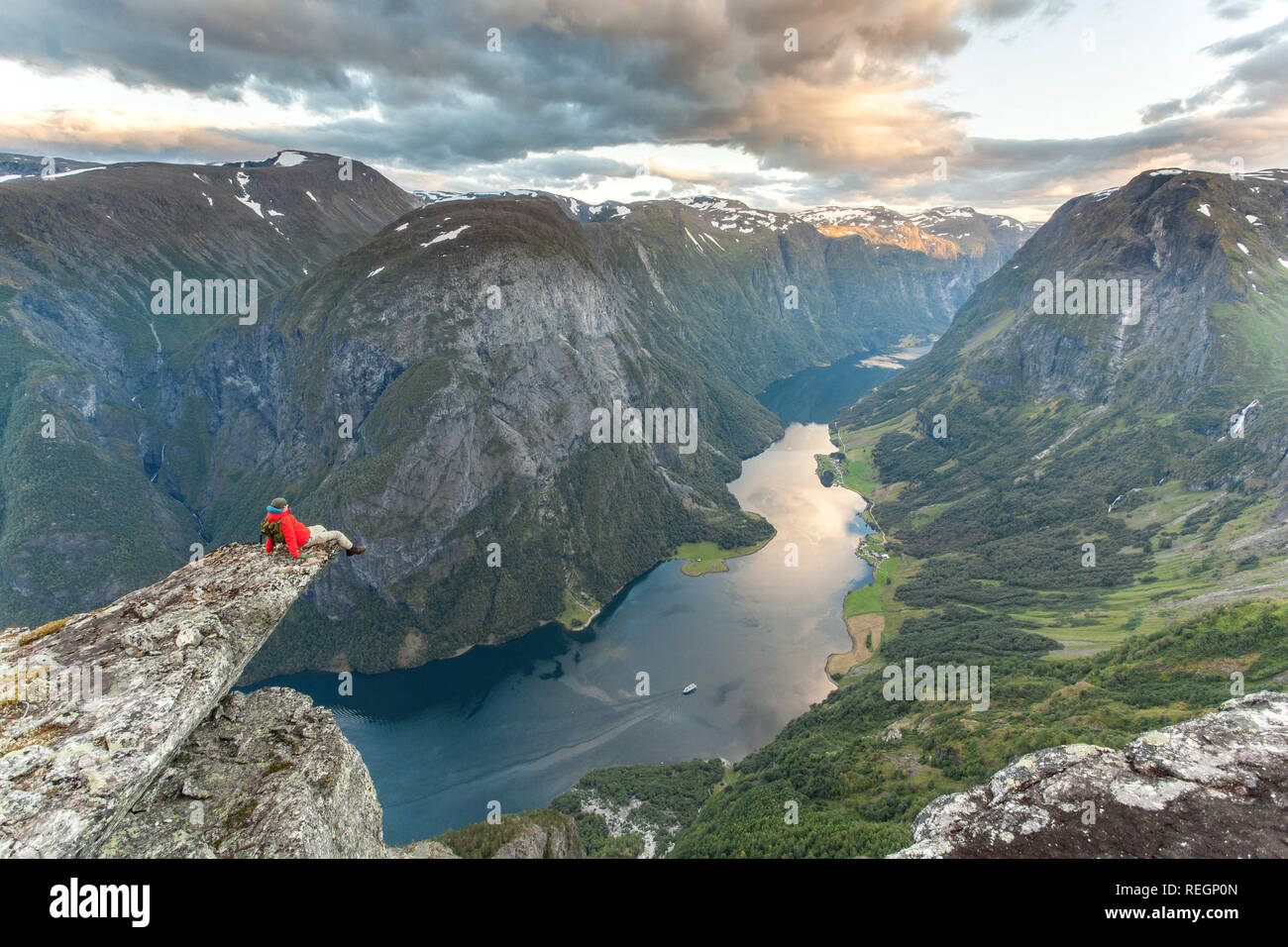 Un escursionista godendo di una magnifica vista del fiordo norvegese vicino a Gudvangen. Unesco World Heritage Site di Naeroyfjord, Norvegia. Foto Stock