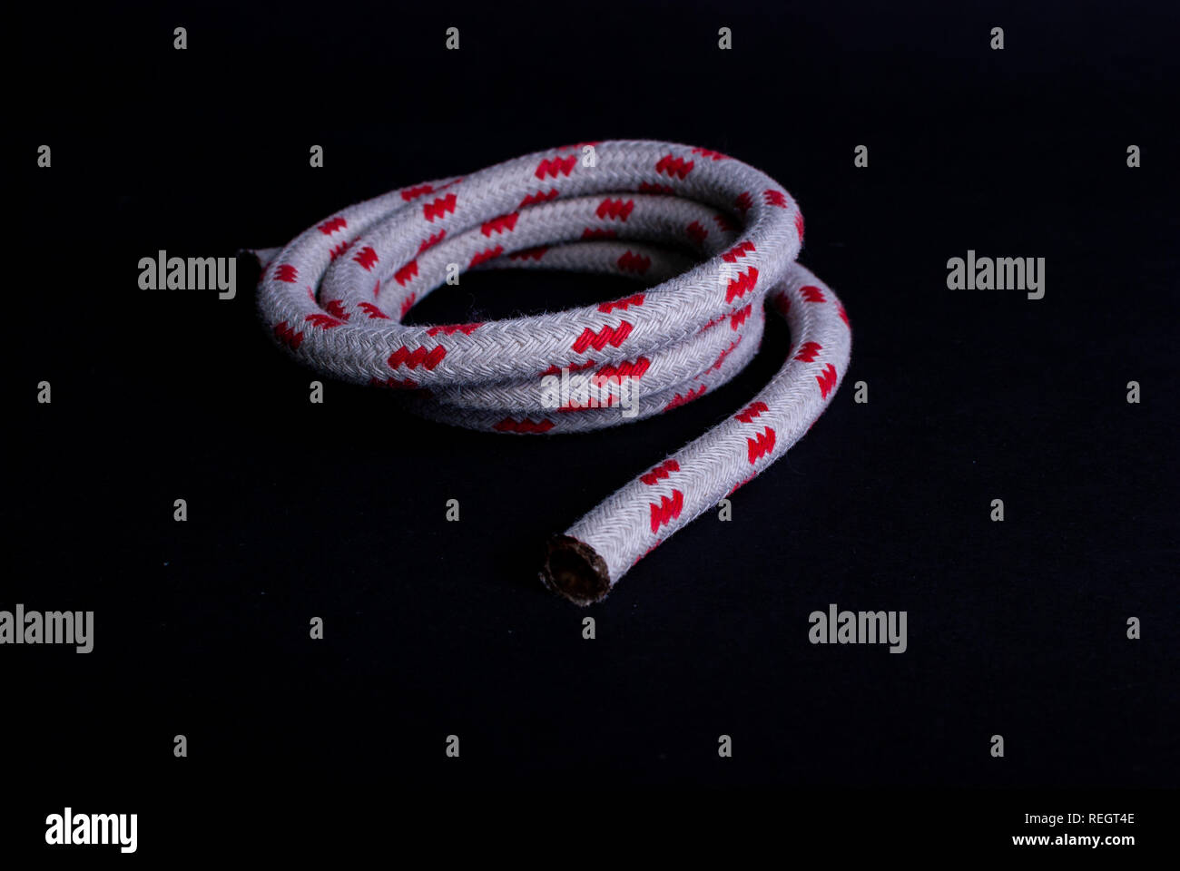 Close up di un rosso e bianco corda a vela su sfondo nero Foto Stock