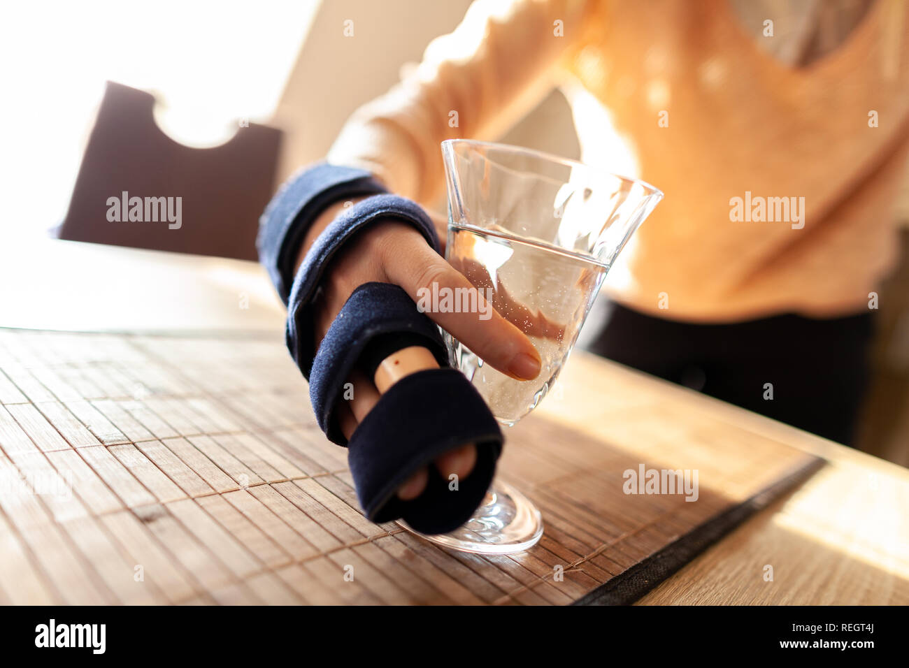 Mano trattiene un bicchiere di acqua con un medico di imbracatura a mano Foto Stock