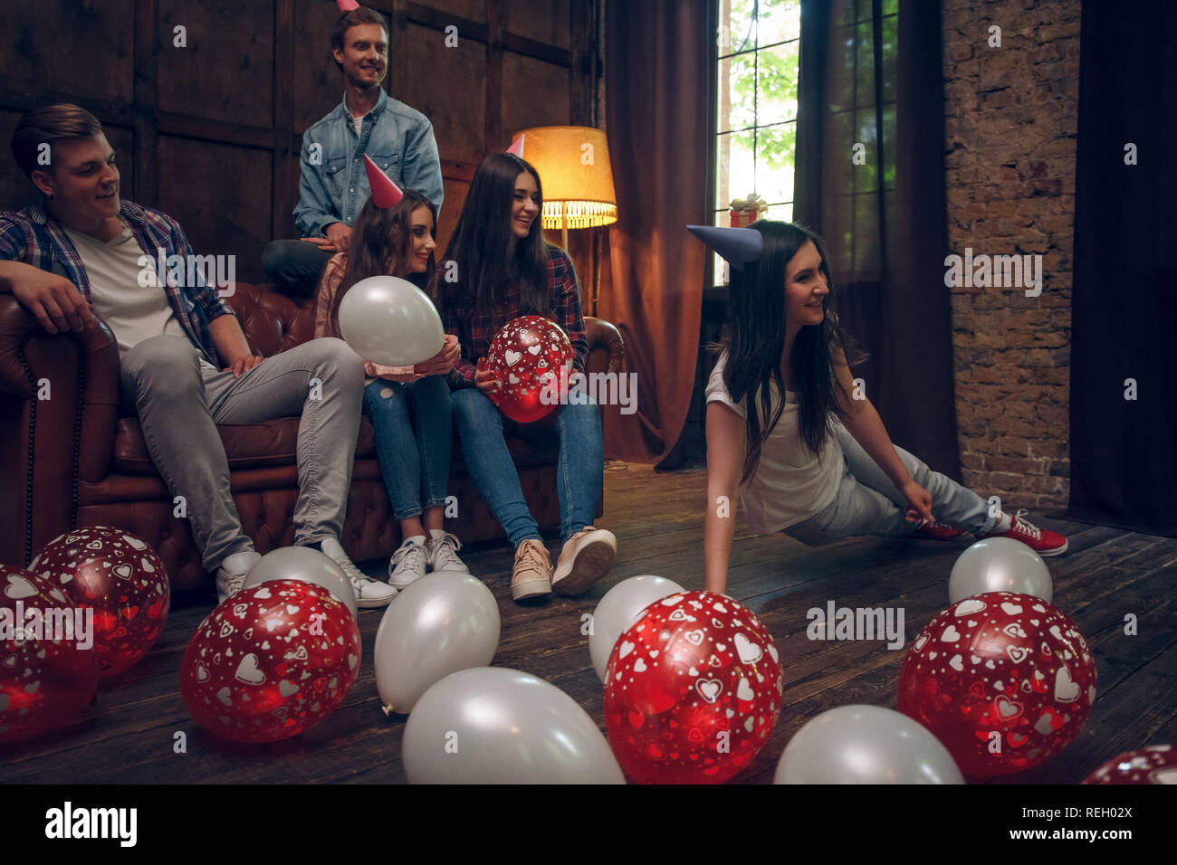 Sorridente amici appendere fuori a giocare sciarade alla festa di compleanno Foto Stock