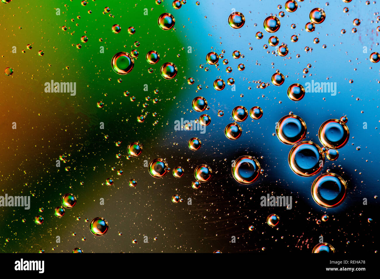 Macro shot di liquidi retroilluminato con piccole bolle su sfondo colorato. Foto Stock