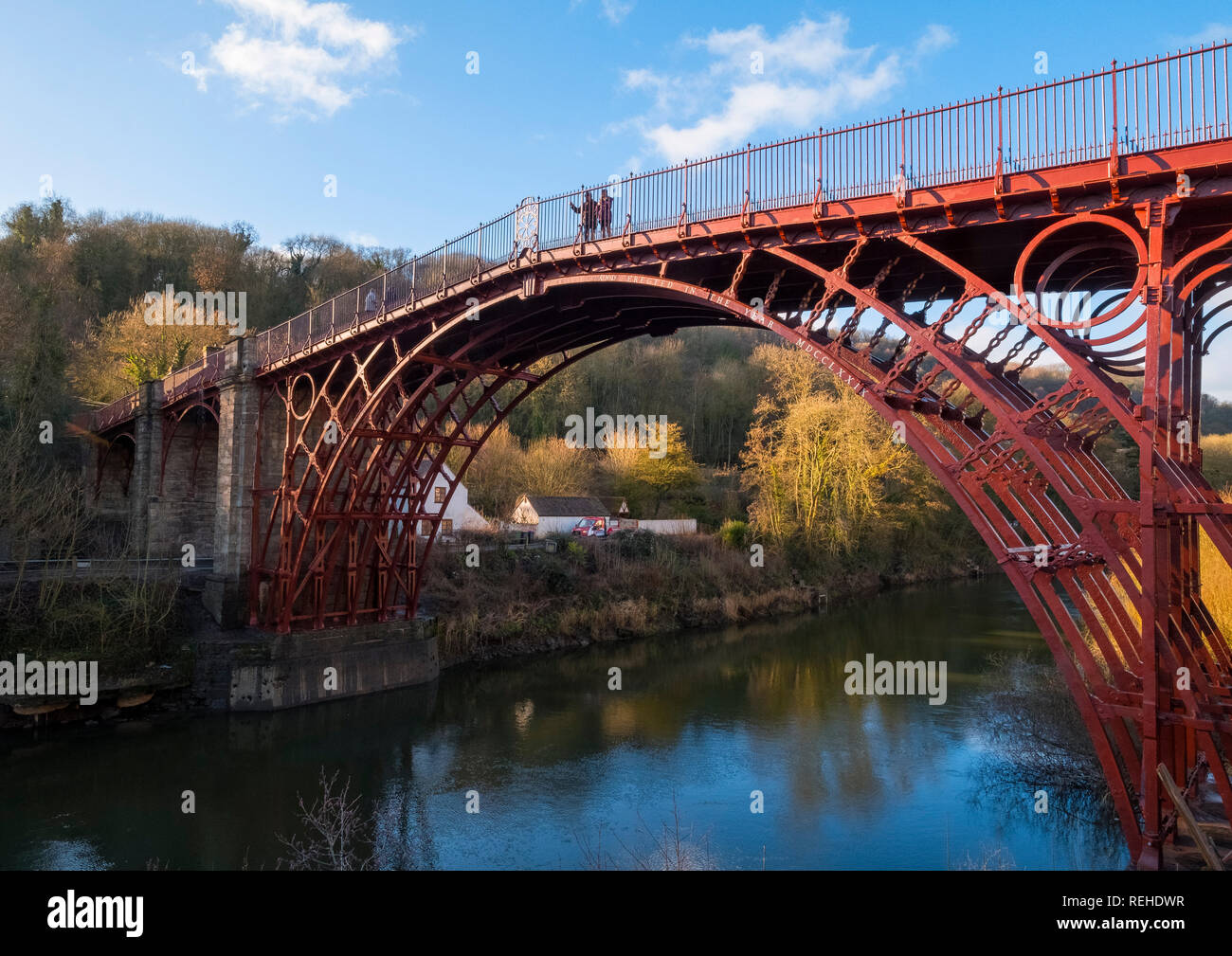 Il sole d'inverno mette in risalto il colore rosso del ponte di ferro sul fiume Severn di Ironbridge, Shropshire, Inghilterra, Regno Unito Foto Stock