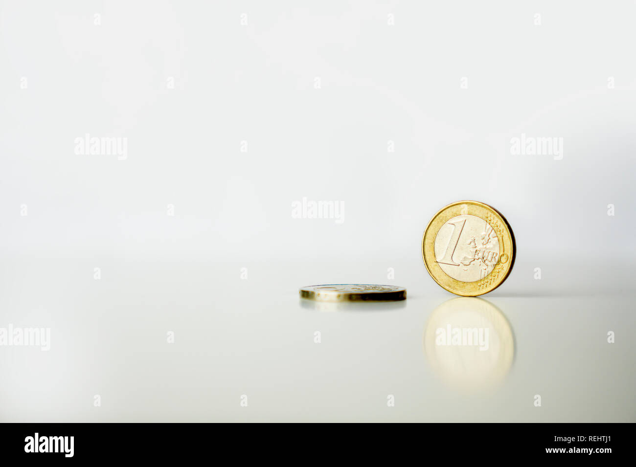 Utilizzate un 1 e due 2 monete in euro con la riflessione sullo sfondo bianco Foto Stock
