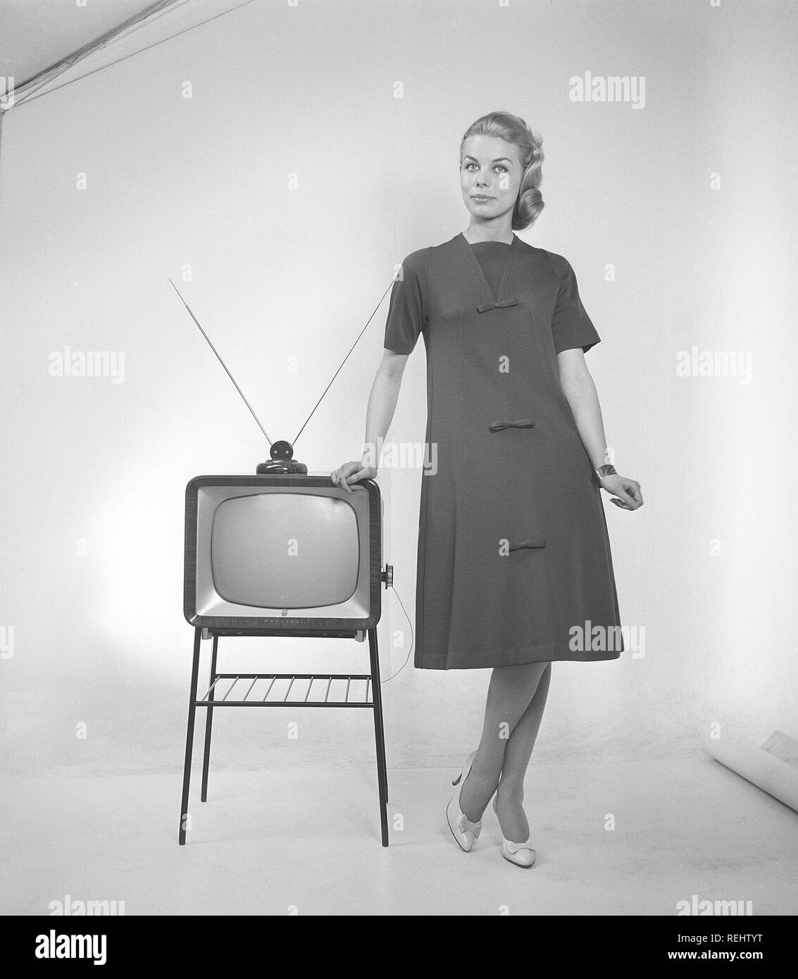 La televisione negli anni cinquanta. Una giovane donna è in piedi vestito in un tipico 50s abito accanto a un televisore con un tabella antenna sulla sommità di esso. Nel 1952 1,4 milioni di famiglie in Gran Bretagna aveva un televisore. Foto Kristoffersson ref BZ26. La Svezia 1952 Foto Stock