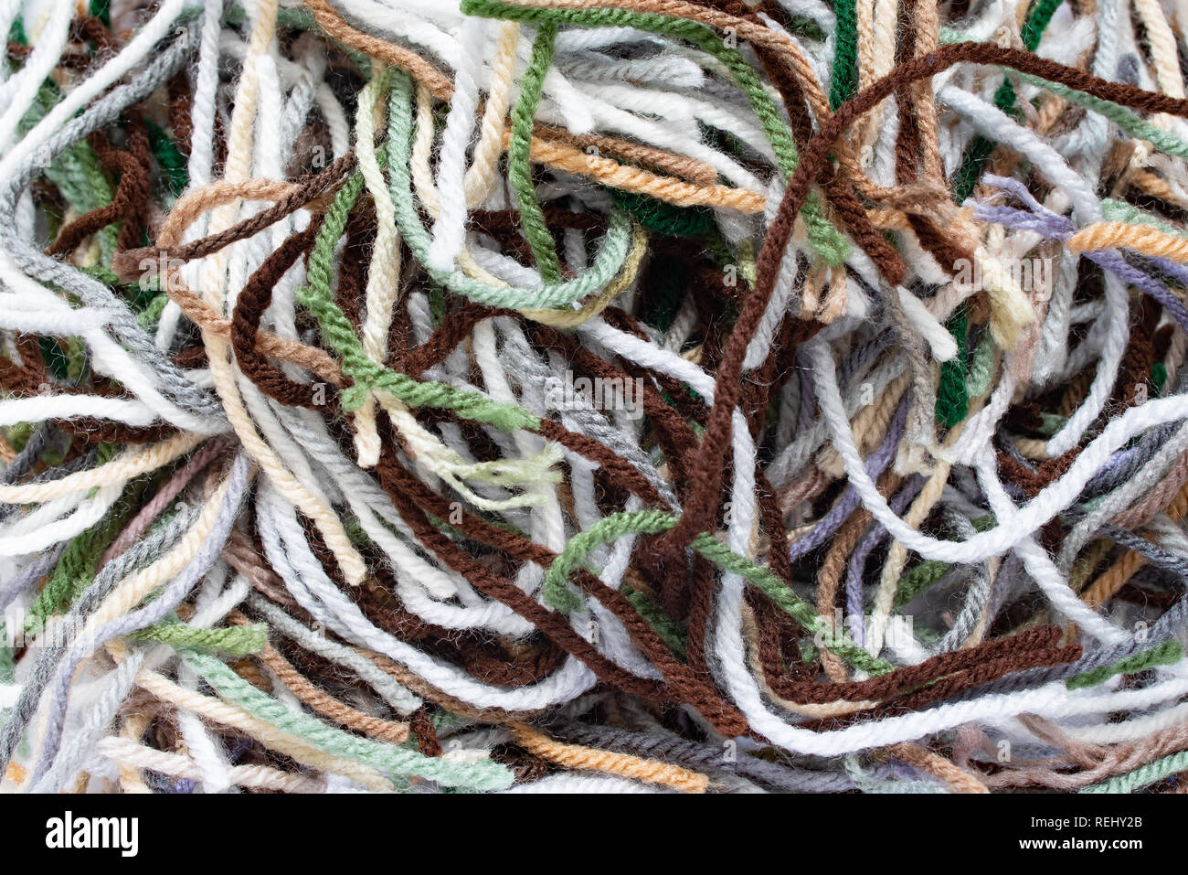 Un mucchio di filati acrilici pezzi in molti colori lasciati da un crochet afghani. Foto Stock