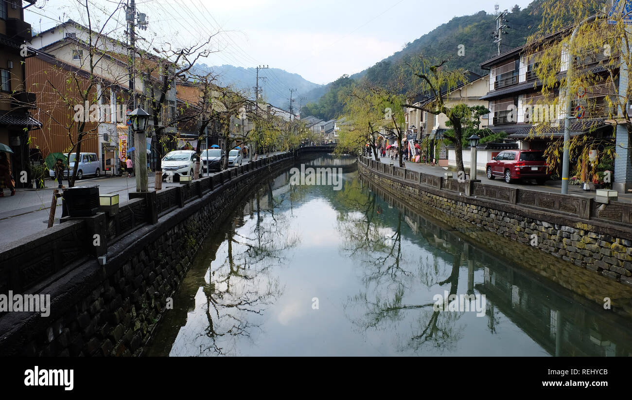 Canal in Kinosaki primavera calda città, Giappone. Lungo entrambi i lati del canale sono negozi, ryokan e case. Foto Stock