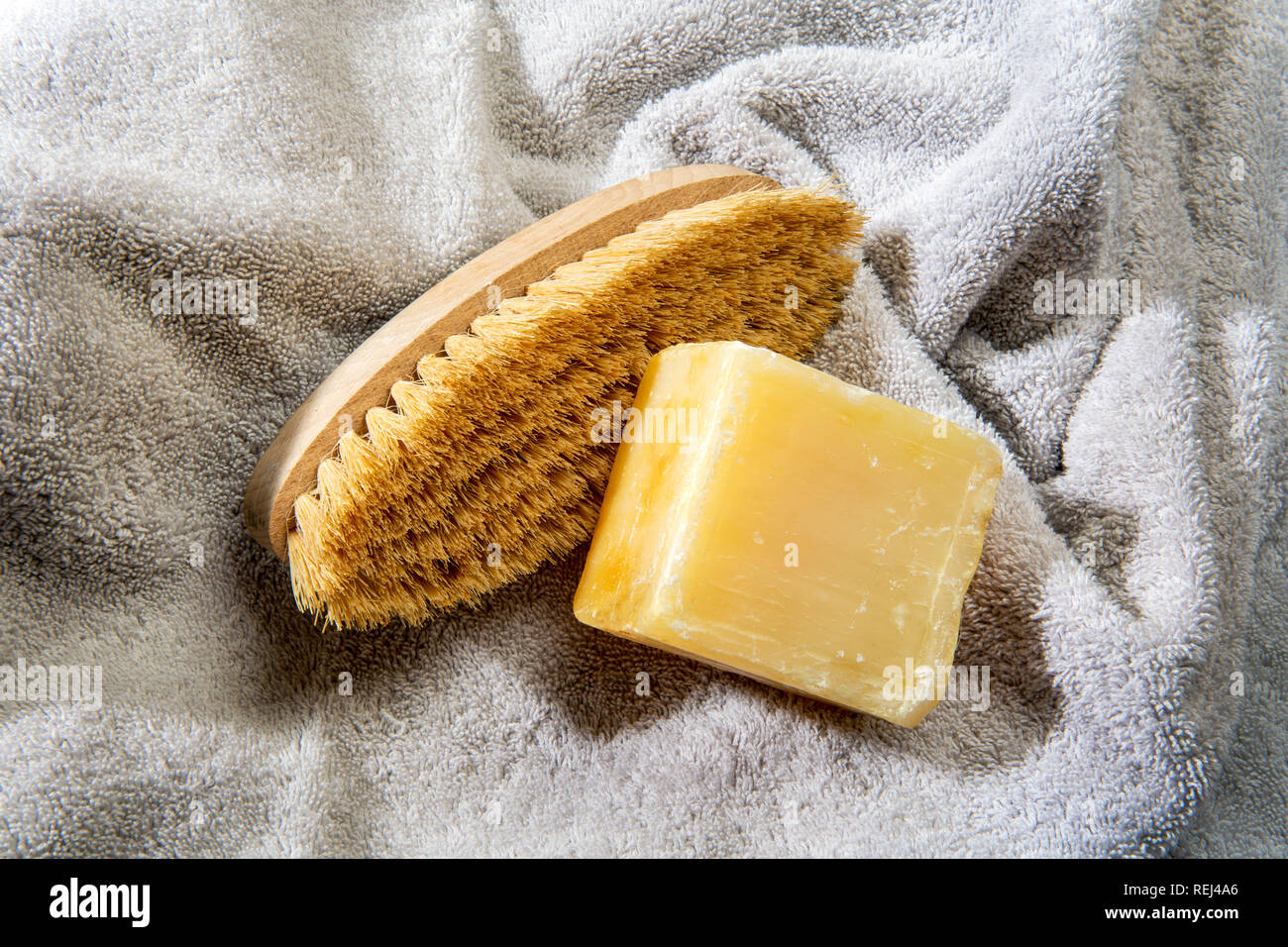Bar della tradizione francese di Marsiglia sapone duro con spazzola a setole e asciugamano morbido realizzato con naturale oli vegetali in una bellezza e di un concetto di igiene Foto Stock